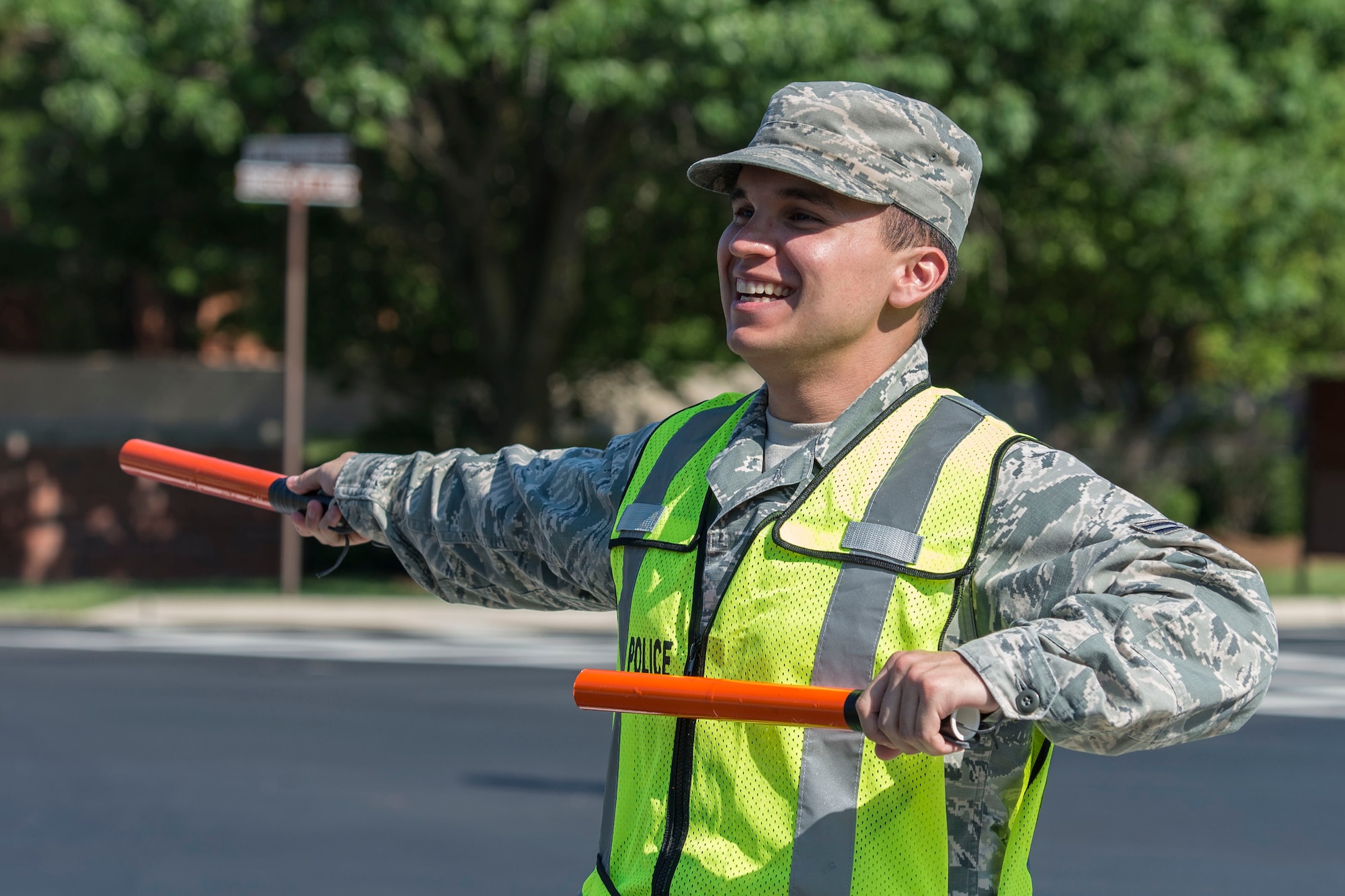 A volunteer directs traffic during the Centennial Celebration Air Show, June 11, 2017, Scott Air Force Base, Ill. Scott AFB opened in 1917, previously named Scott Field, the base has seen its mission evolve and expand to encompass a multitude of priorities, including aeromedical evacuation and communications. (U.S. Air Force photo by Senior Airman Melissa Estevez)