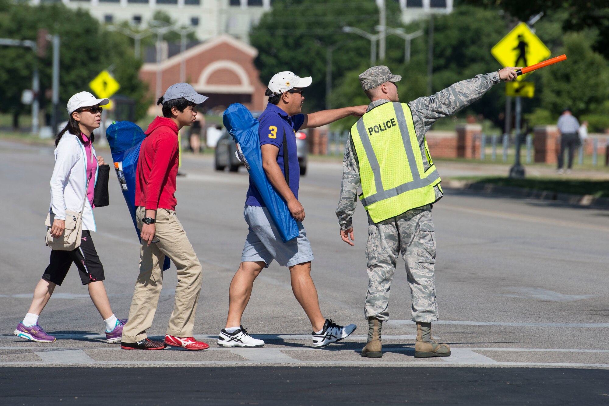 A volunteer directs traffic during the Centennial Celebration Air Show, June 11, 2017, Scott Air Force Base, Ill. Scott AFB opened in 1917, previously named Scott Field, the base has seen its mission evolve and expand to encompass a multitude of priorities, including aeromedical evacuation and communications. (U.S. Air Force photo by Senior Airman Melissa Estevez)