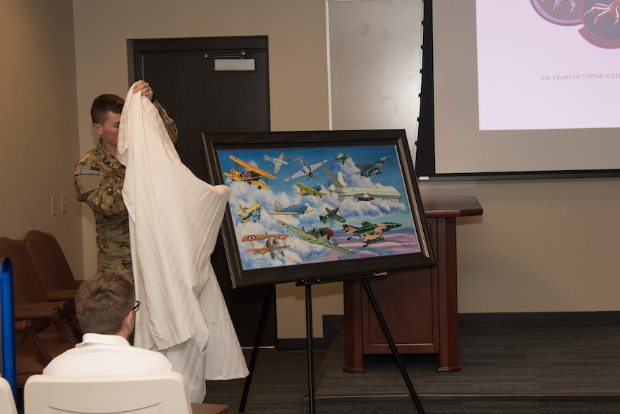 A painting containing all the aircraft the squadron has flown during its history is revealed during the 33rd Special Operations Squadron 100-year ceremony at Cannon Air Force Base, June 9, 2017. The squadron has roots dating back to 1917 during World War I and since then has had a presence in nearly every major U.S. conflict. (U.S. Air Force photo by Staff Sgt. Michael Washburn/Released)