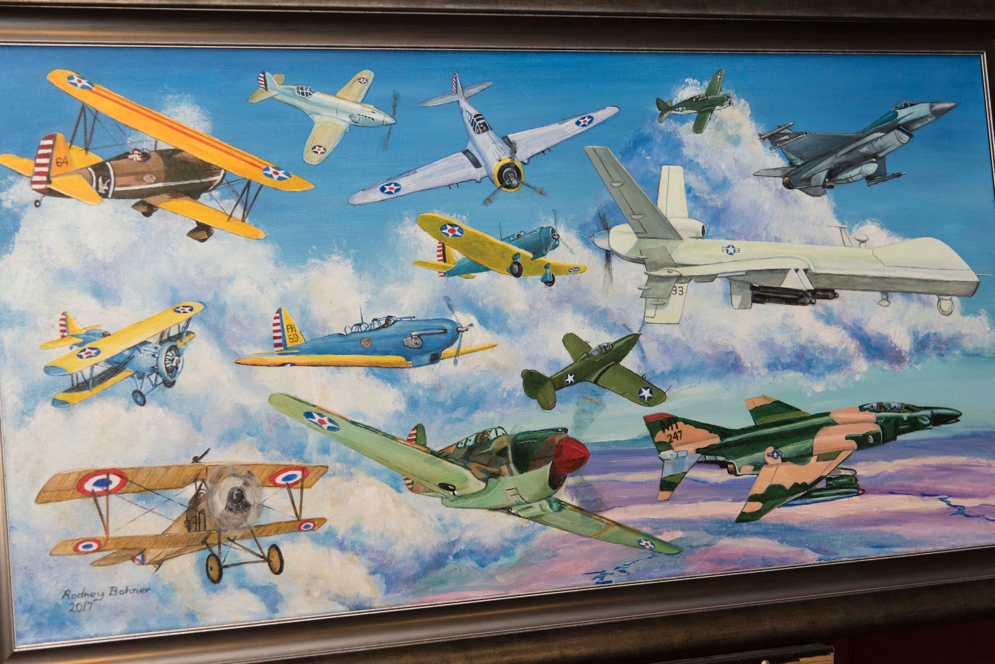 A painting depicting the aircraft used during the 33rd Special Operations Squadron’s 100-year history is revealed during the 33rd SOS 100-year ceremony at Cannon Air Force Base, New Mexico, June 9, 2017. The painting was done by Rodney Bohner, father of Lt. Col. Ryan Bohner, 33rd SOS commander. (U.S. Air Force photo by Staff Sgt. Michael Washburn/Released)