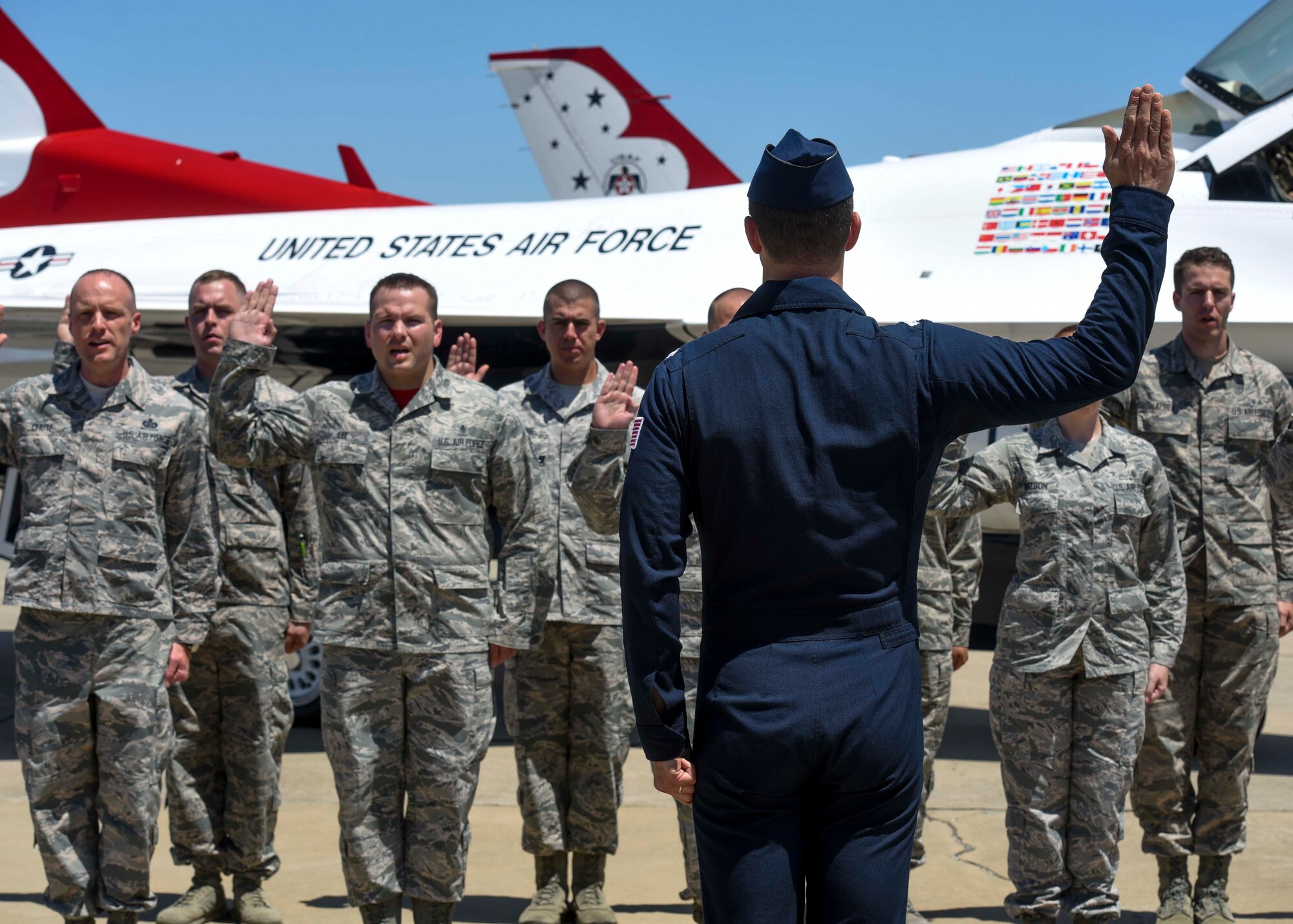 A group of Airmen reenlist into the Air Force with the Thunderbirds during the Scott Air Force Base Air Show, Scott Air Force Base, Ill., June 11, 2017. The base hosted the air show and open house to celebrate the 100th year of Scott AFB.  Over 50 aircraft, ranging from WWI’s Curtiss JN-4 Jenny to the currently utilized KC-135 Stratotanker, came to Scott, the fourth oldest Air Force base. Demonstrations included the Black Daggers, “Tora, Tora, Tora,” and the USAF Thunderbirds. Opened in 1917 and previously named Scott Field, the base has seen its mission evolve and expand to encompass a multitude of priorities, including aeromedical evacuation and communications.  Today, Scott is home to 31 mission partners and provides around-the-clock logistics support and rapid global mobility, carried out primarily by U.S. Transportation Command and Air Mobility Command.