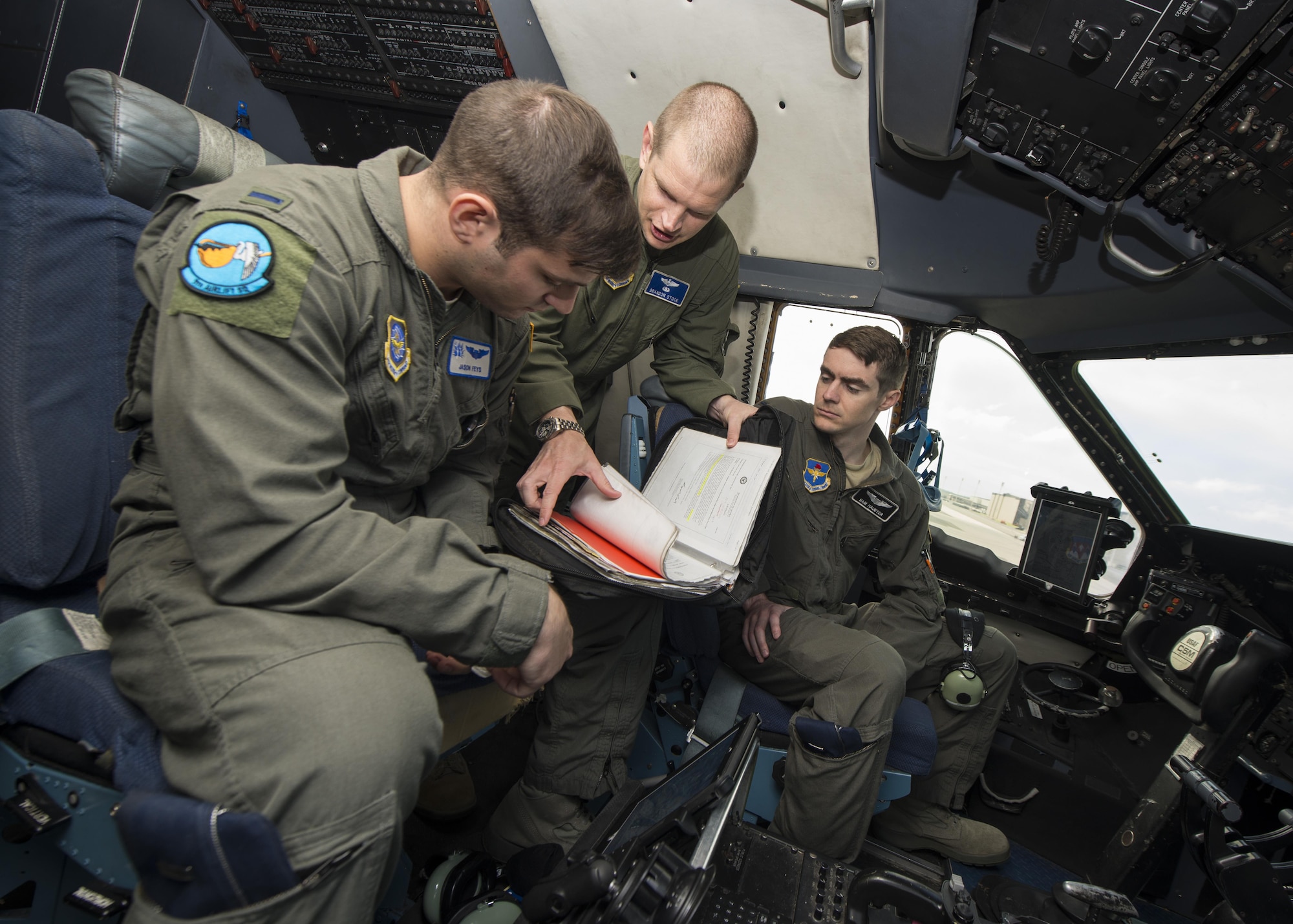 Maj. Brandon Stock, C-5M Formal Training Unit commander, instructs pilot students, 1st Lt. Jason Feys and 1st Lt. Sam Haueter, during preflight procedures June 8, 2017, inside a C-5M Super Galaxy flight deck on Dover Air Force Base, Del. Feys and Haueter are undergoing C-5M initial pilot qualification training. (U.S. Air Force photo by Senior Airman Zachary Cacicia)