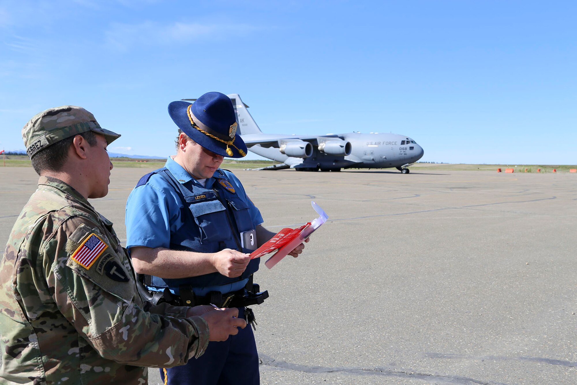 Alaska National Guard Sgt. Elijah Gutierrez, a civil operator with the Counterdrug Support Program, discusses the procedures for using the Narcan kit with Alaska State Trooper James Lester at the Edward G. Pitka Sr. Airport in Galena, Alaska, May 31, 2017. Twelve Guardsmen from the CDSP traveled to the Yukon-Koyukuk Region hub to deliver the kits that block the effects of opioids and reverses an overdose, and to provide drug and alcohol education and prevention materials to local residents. (U.S. Army National Guard photo by Staff Sgt. Balinda O’Neal Dresel)