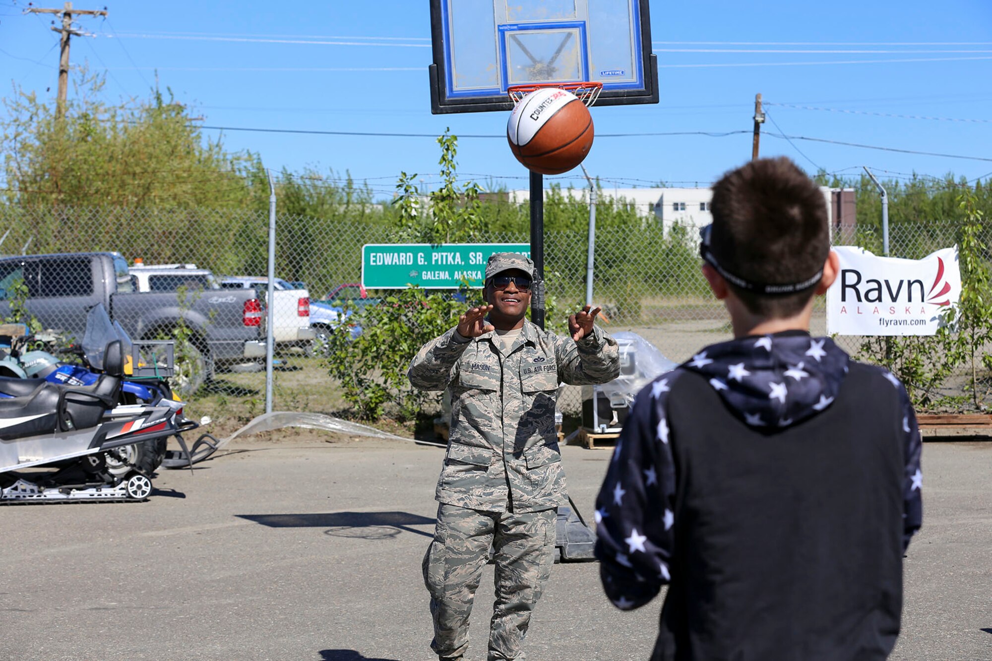 Alaska National Guard Staff Sgt. Dneko Mason, with the Counter Drug Support Program, passes a basketball to a young boy wearing vision impairment goggles, a prevention tool used to demonstrate alcohol or drug impairment, at the Edward G. Pitka Sr. Airport in Galena, Alaska, May 31, 2017. The CDSP presented the goggles, a tool used to demonstrate alcohol or drug impairment, and provided drug and alcohol education and prevention materials to local residents during a recent civil operations mission in the Yukon-Koyukuk Region. (U.S. Army National Guard photo by Staff Sgt. Balinda O’Neal Dresel)