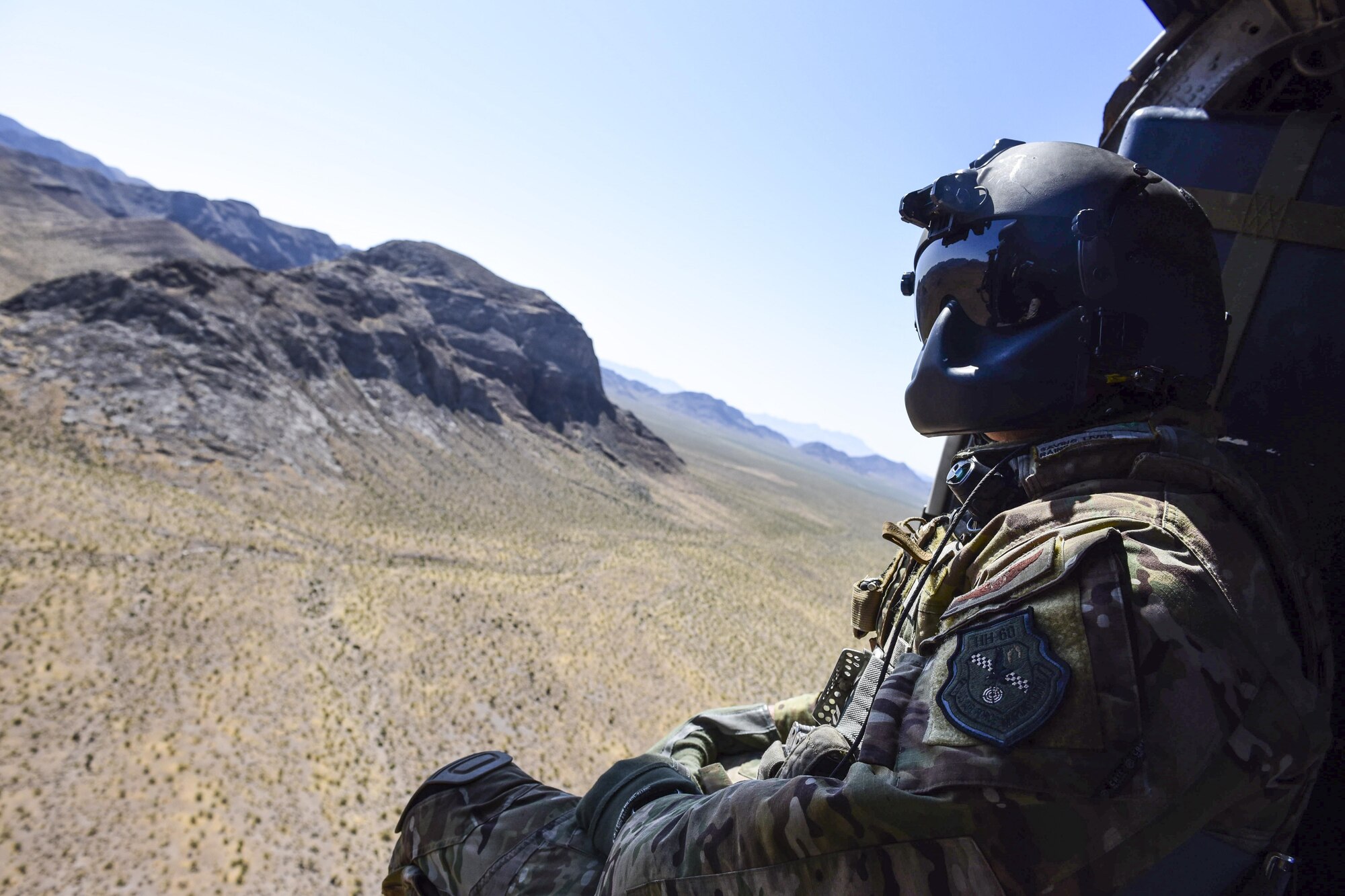 Staff Sgt. Christian Nault, 34th Weapons Squadron special mission aviator, searches the area for the landing zone during a Weapons School Integration mission at the Nevada Test and Training Range June 1, 2017. The HH-60 crew successfully performed a combat search and rescue mission during the exercise. (U.S. Air Force photo by Airman 1st Class Andrew D. Sarver/Released)