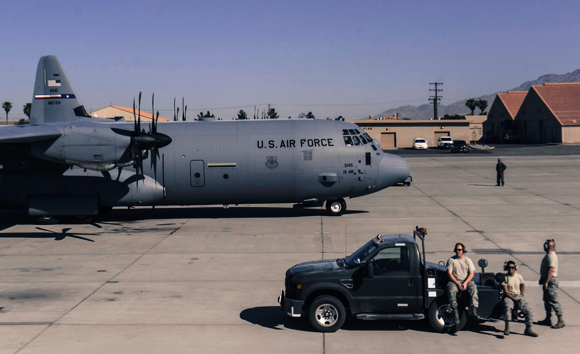 Aircraft maintainers watch as a C-130J Super Hercules prepares for takeoff before a Weapons School Integration mission at Nellis Air Force Base, Nev., June 2, 2017. Students who take the Weapons School course receive an average of 400 hours of graduate-level academics and participate in demanding combat training missions. (U.S. Air Force photo by Senior Airman Kevin Tanenbaum/Released) 