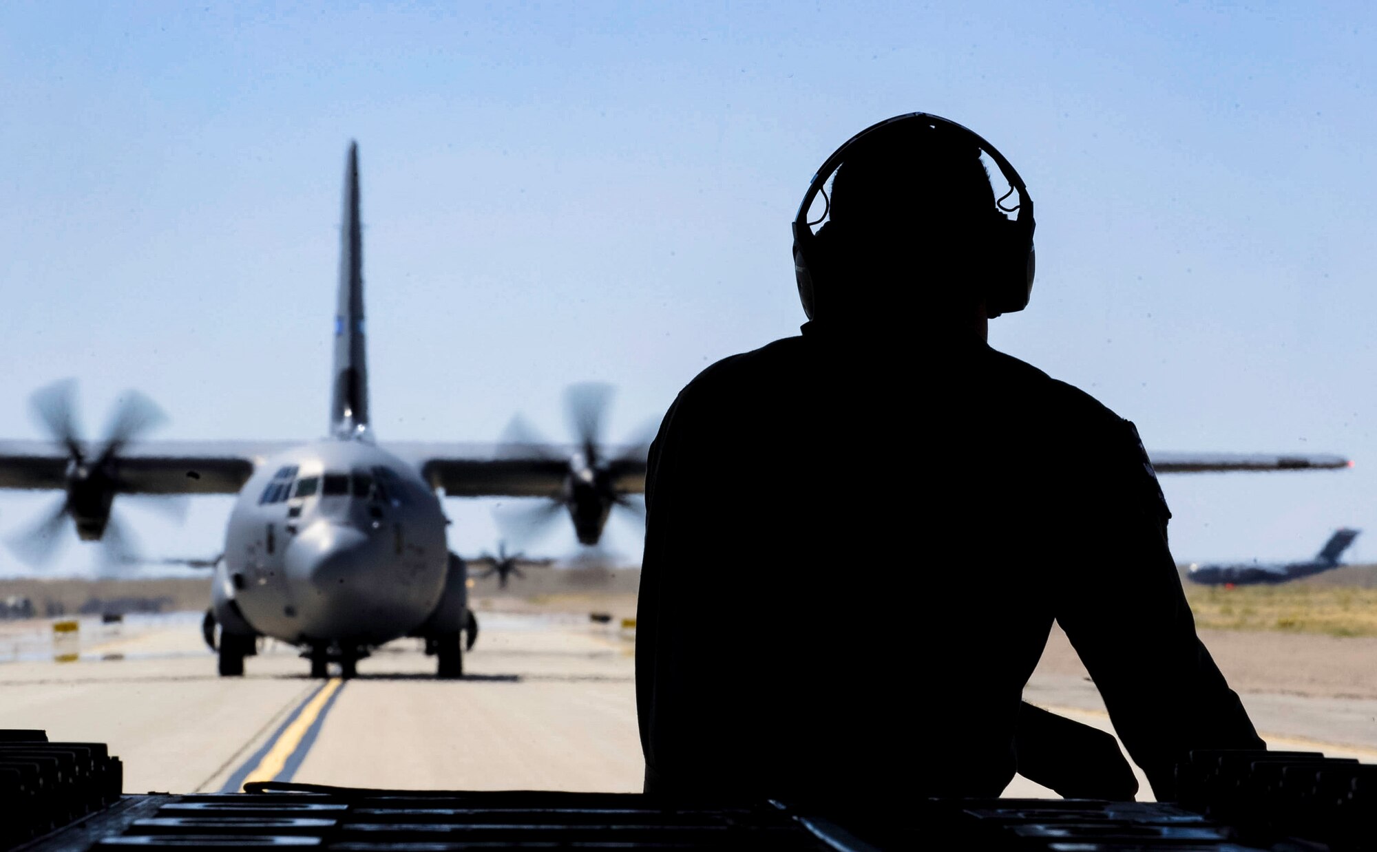 A crew chief sits on the ramp of a C-130J Super Hercules during a Weapons School Integration mission on the Nevada Test and Training Range, Nev., June 2, 2017. While landed, the cargo aircraft simulated loading nearly 1,000 people as part of the overall mission. (U.S. Air Force photo by Senior Airman Kevin Tanenbaum/Released) 