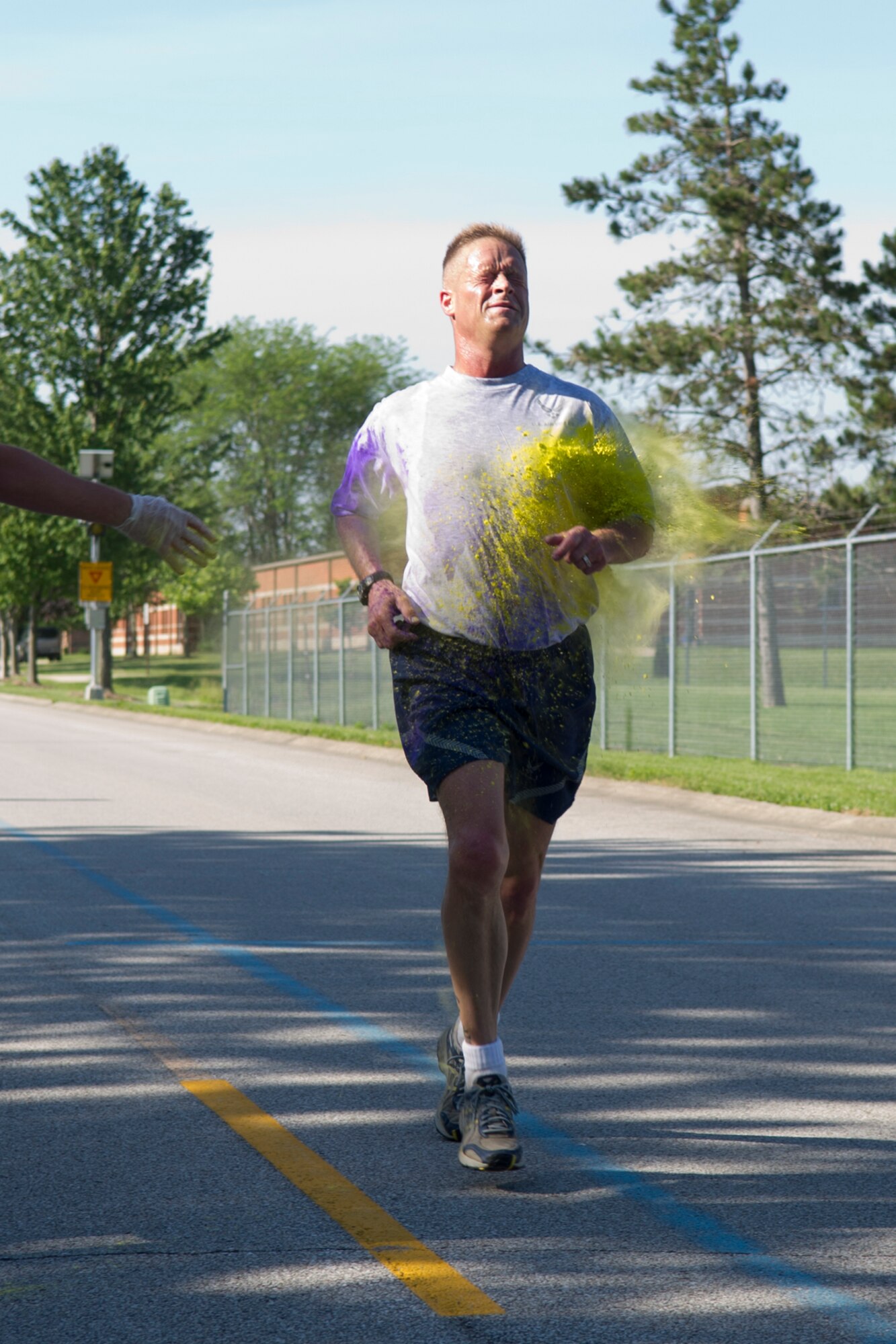 Louis Poggerburg, 434th Security Forces Squadron administrator, gets dusted by a cloud of color during a 5K color fun run held June 3, 2017. This run was the kick-start to a very colorful, eventful family day. (U.S. Air Force photo/Senior Airman Cali Wetli)