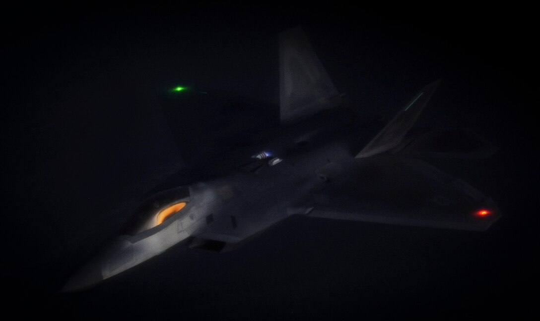 An F-22 Raptor fighter jet, assigned to the 433rd Weapons Squadron at Nellis Air Force Base, Nev., maneuvers after being refueled by a KC-135 Stratotanker during a Weapons School Integration mission over the Nevada Test and Training Range June 8, 2012. One of the most important planned aspects of this mission is holding it during the hours of darkness. (U.S. Air Force photo by Senior Airman Kevin Tanenbaum/Released)
