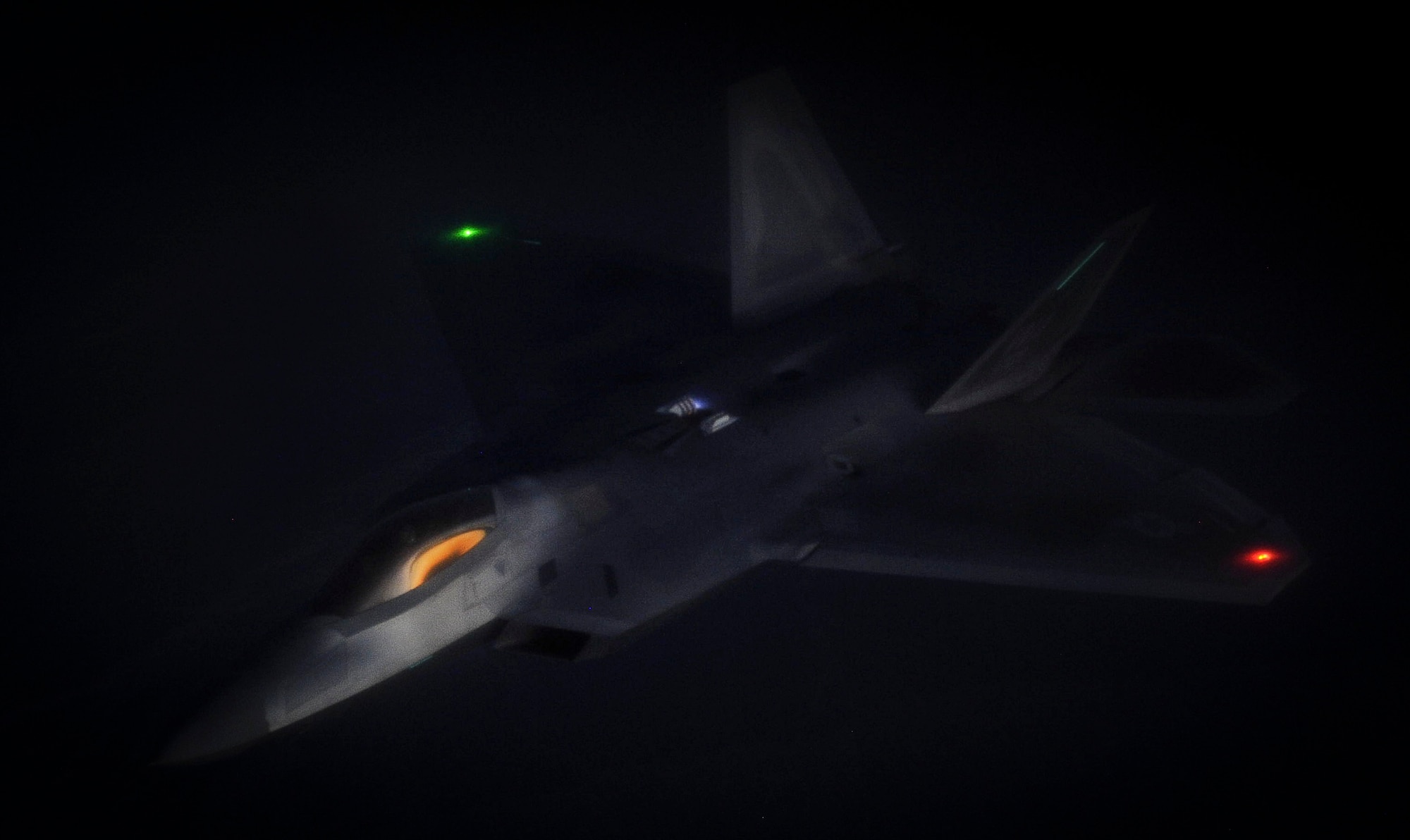 An F-22 Raptor fighter jet, assigned to the 433rd Weapons Squadron at Nellis Air Force Base, Nev., maneuvers after being refueled by a KC-135 Stratotanker during a Weapons School Integration mission over the Nevada Test and Training Range June 8, 2012. One of the most important planned aspects of this mission is holding it during the hours of darkness. (U.S. Air Force photo by Senior Airman Kevin Tanenbaum/Released)
