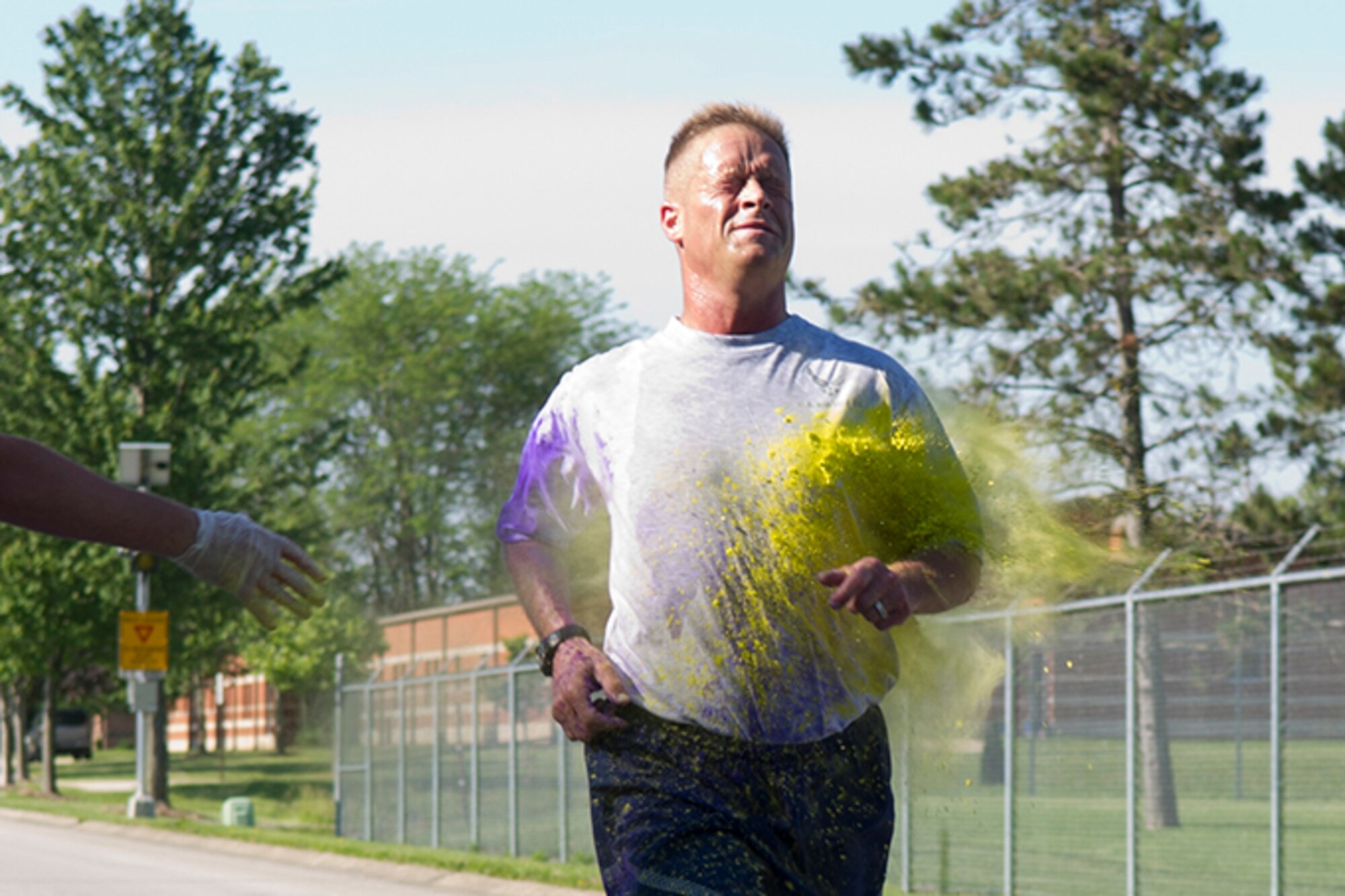 Louis Poggerburg, 434th Security Forces Squadron administrator, gets dusted by a cloud of color during a 5K color fun run held June 3, 2017. This run was the kick-start to a very colorful, eventful family day. (U.S. Air Force photo/Senior Airman Cali Wetli)