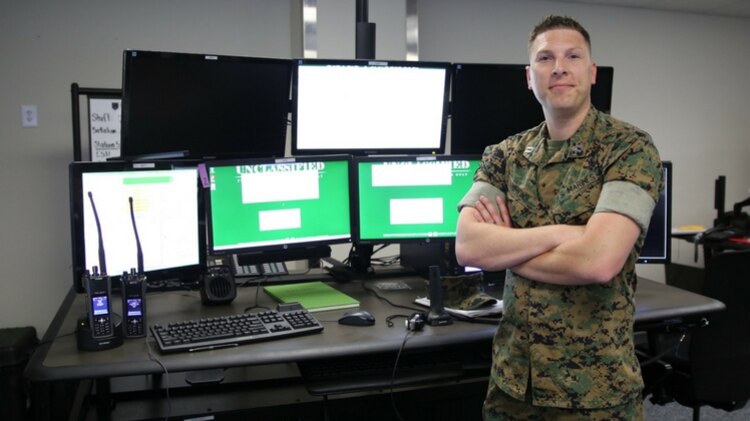 A man standing in front computers, which were originally developed military use