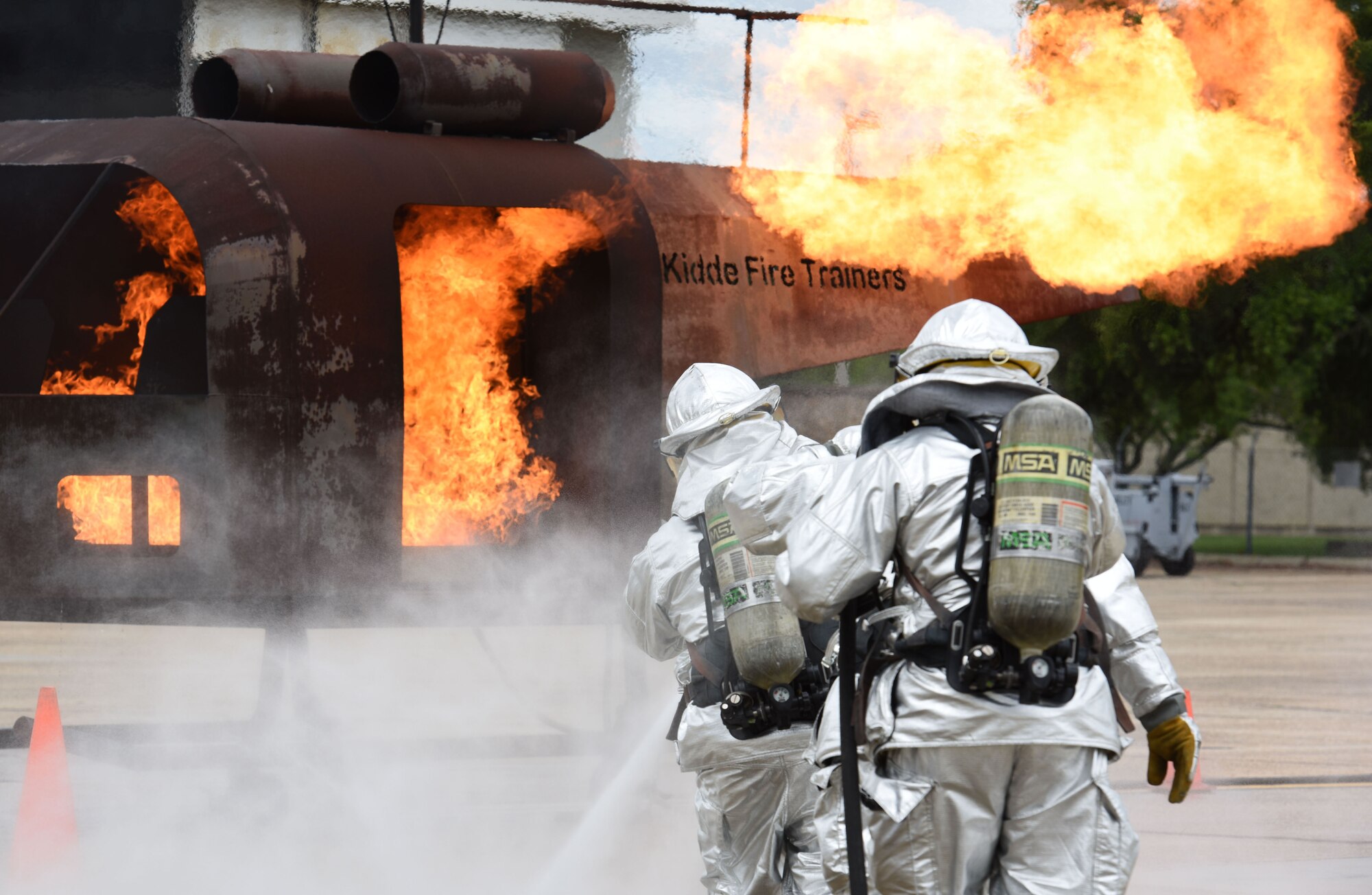 Keesler firefighters use a hand-held hose to extinguish a firefighter training aid during a live fire exercise on the flightline June 6, 2017, on Keesler Air Force Base, Miss. The Keesler Fire Department, the Gulfport CRTC Fire Department and the Stennis Space Center Fire Department are all required to practice Aircraft Rescue and Fire Fighting procedures to meet a semi-annual training requirement. (U.S. Air Force photo by Kemberly Groue)