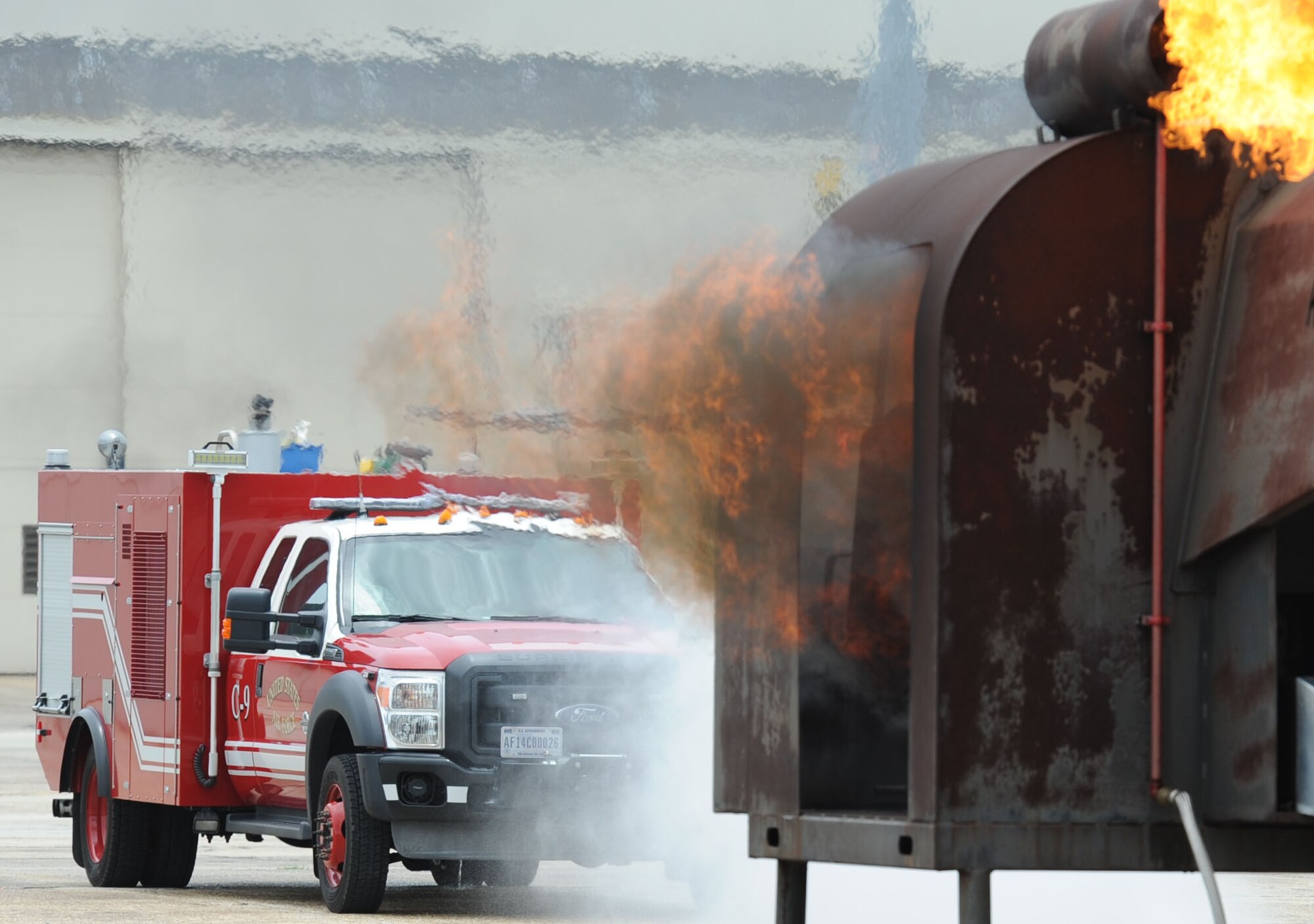 Keesler firefighters use a fire truck’s turret hose on a firefighter training aid during a live fire exercise on the flightline June 6, 2017, on Keesler Air Force Base, Miss. The Keesler Fire Department, the Gulfport CRTC Fire Department and the Stennis Space Center Fire Department are all required to practice Aircraft Rescue and Fire Fighting procedures to meet a semi-annual training requirement. (U.S. Air Force photo by Kemberly Groue)