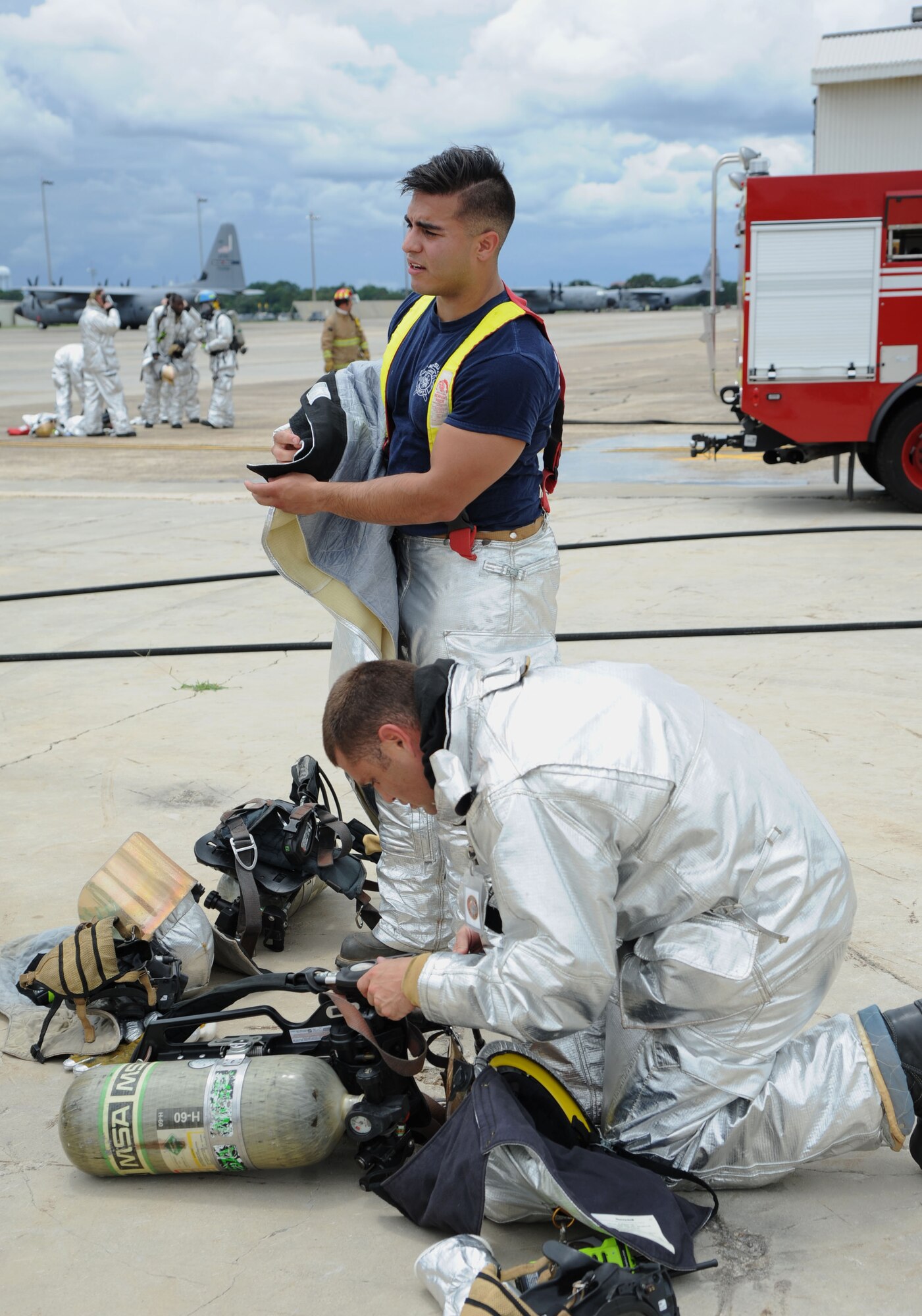 Staff Sgt. Daniel Braitman and Senior Airman Jonathan Martinez, 81st Infrastructure Division firefighters, gear up during a live fire exercise on the flightline June 6, 2017, on Keesler Air Force Base, Miss. The Keesler Fire Department, the Gulfport CRTC Fire Department and the Stennis Space Center Fire Department are all required to practice Aircraft Rescue and Fire Fighting procedures to meet a semi-annual training requirement. (U.S. Air Force photo by Kemberly Groue)