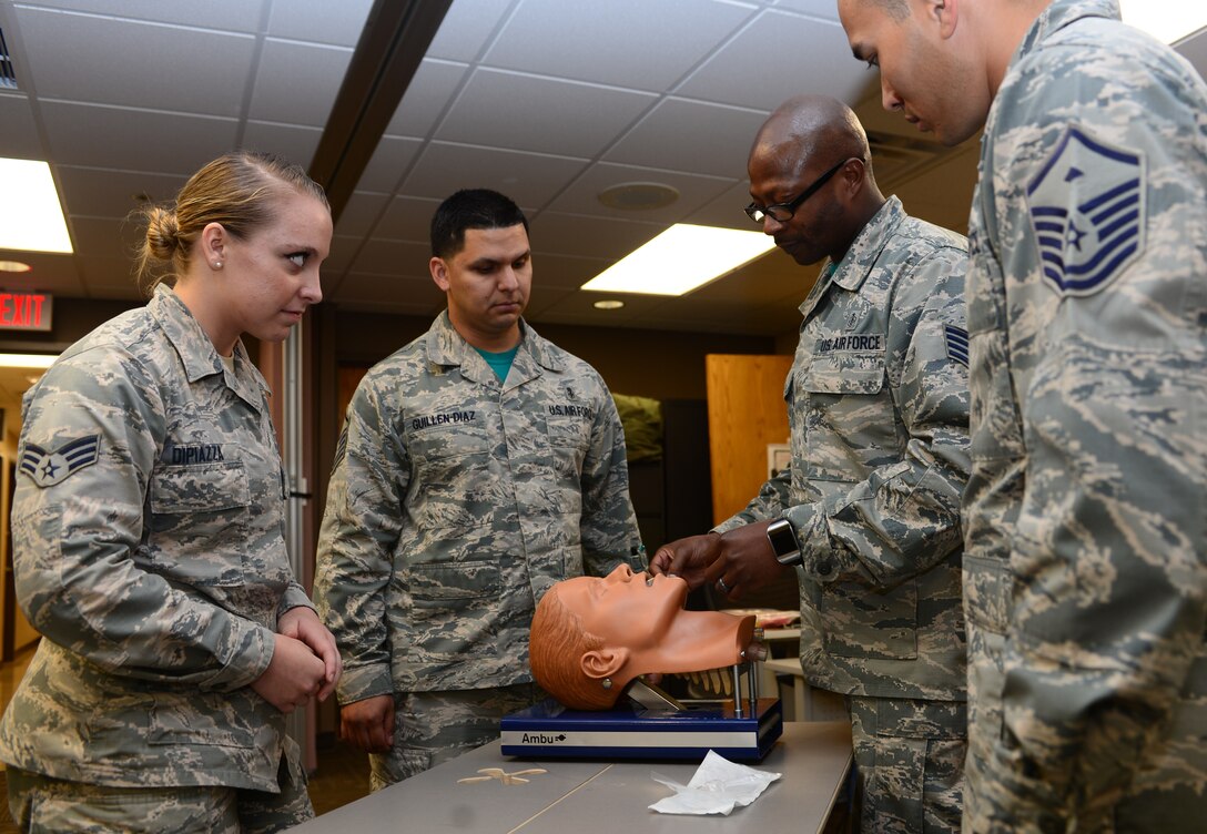 Master Sgt. Nathan Landry, the first sergeant assigned to the 28th Medical Group, and Master Sgt. Luis Guillen-Diaz, the mental health flight chief and additional-duty first sergeant assigned to the 28th MDG, join Staff Sgt. Ricky Dunbar, an education and training noncommissioned officer in charge assigned to the 28th MDG, while he teaches a course on CPR at Ellsworth Air Force Base, S.D., June 9, 2017. Each first sergeant has a handful of additional-duty first sergeants, usually around four or five, ready to drop what they’re doing at moment’s notice to take up the mantel. (U.S. Air Force photo by Airman 1st Class Donald C. Knechtel)
