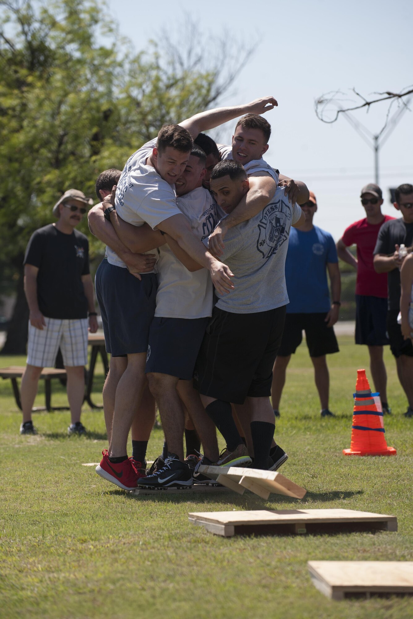 The 7th Civil Engineer Squadron Fire Department team works together for the River Rescue Crossing event during Battle of the Badges at Dyess Air Force Base, Texas, June 10, 2017. For the River Rescue Crossing event, teams work together to get from one side to the other with a wooden plank. (U.S. Air Force photo by Airman 1st Class April Lancto)