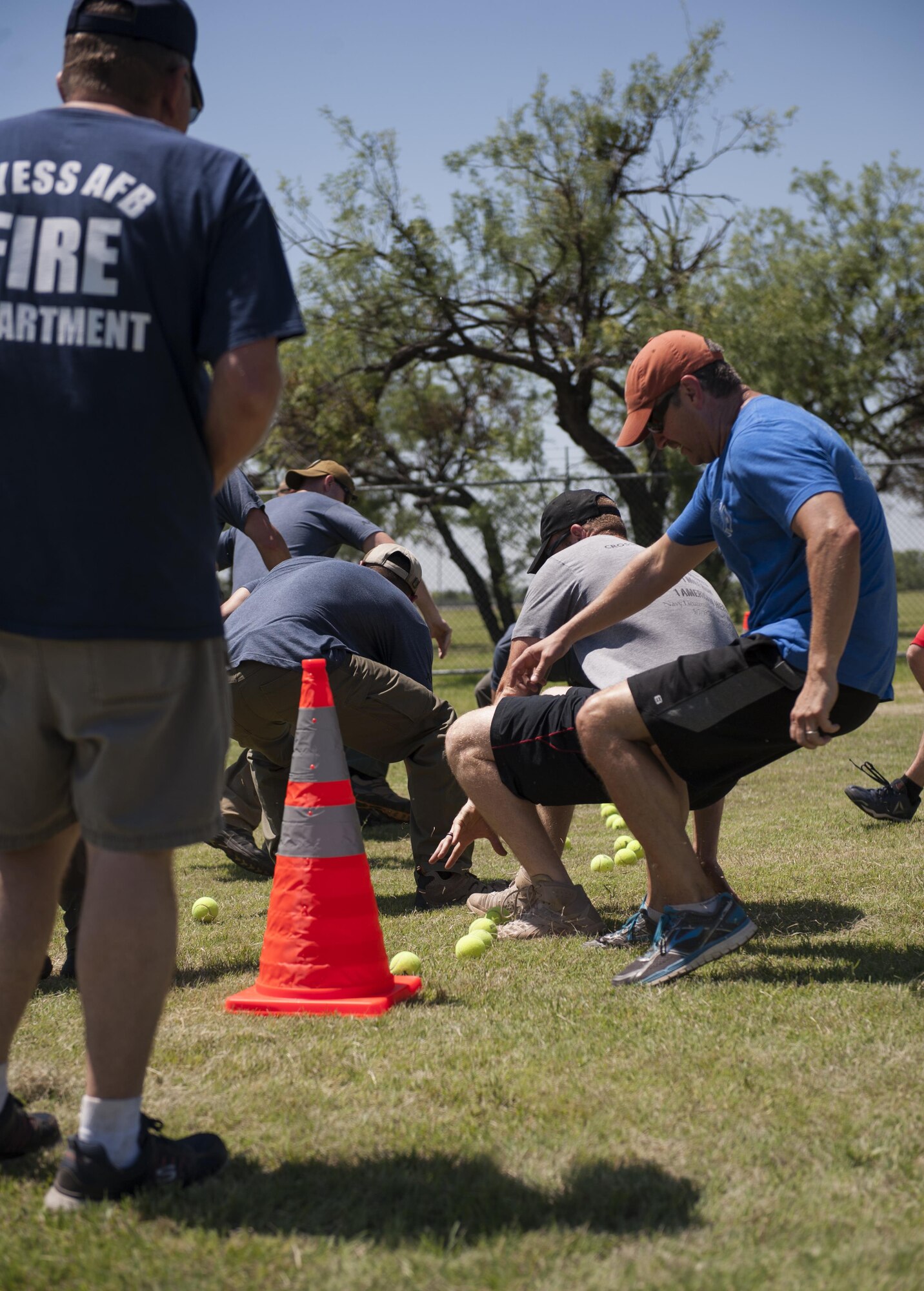 The Abilene Police Department team, left, competes with the Abilene Fire Department, right, during Battle of the Badges at Dyess Air Force Base, Texas, June 10, 2017. During this event, teams raced to get as many tennis balls as they could into their team’s designated bucket. (U.S. Air Force photo by Airman 1st Class April Lancto)