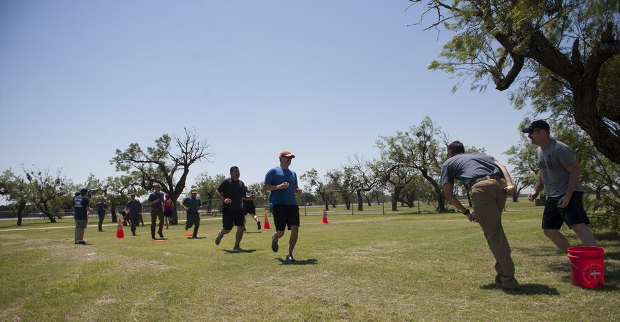 The Abilene Police Department and the Abilene Fire Department teams compete in the last timed event to win the first Battle of the Badges at Dyess Air Force Base, Texas, June 10, 2017. The teams competed in a variety of timed events to include: tire flips, firetruck pull, River Rescue Crossing and slosh pipe carry. (U.S. Air Force photo by Airman 1st Class April Lancto)