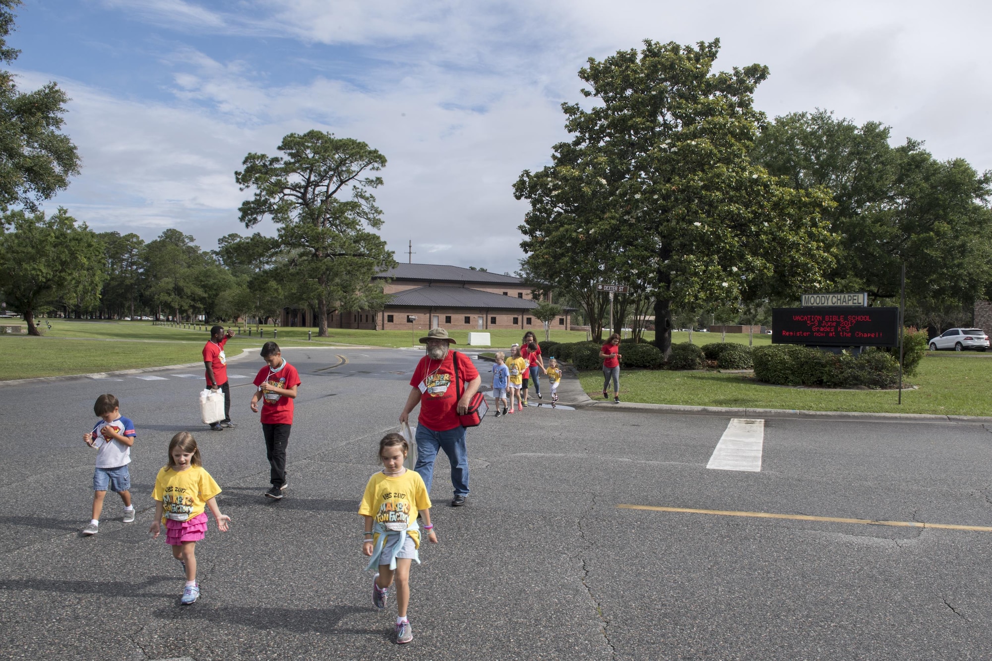 Children and volunteers cross the street to go play games at the Hoffman Auditorium during the base chapel's Vacation Bible School, June 7, 2017 at Moody Air Force Base, Ga. More than 80 people volunteered for this year's VBS and 105 children attended. (U.S. Air Force photo by Tech. Sgt. Zachary Wolf)