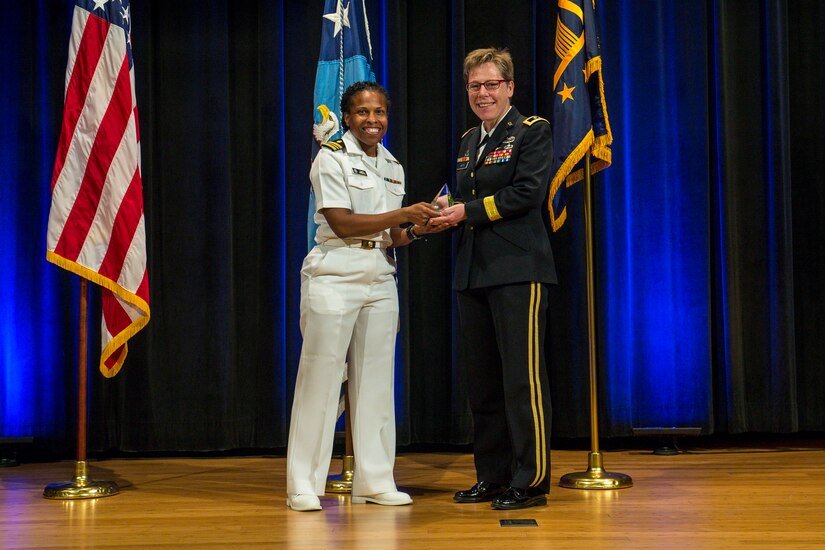 Navy Lt. Cmdr. Damita Zweiback presents a Department of Defense Pride Military Leadership Award to Army Maj. Gen. Tammy S. Smith, deputy commanding general for sustainment of the Eighth Army, during an award ceremony marking LGBT Pride Month at the Pentagon, June 12, 2017. Army photo by Zane Ecklund