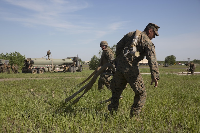 COLD LAKE, AB, CANADA – Cpl. Yhermain Martinezgarcia (front) and Staff Sgt. Brian Beamer (behind), bulk fuel specialists with Marine Wing Support Squadron 473, 4th Marine Aircraft Wing, Marine Forces Reserve, pull a refueling line and fuel meter from an M-970 Semi-Trailer Refueler, at the Canadian Manoeuvre Training Centre during exercise Maple Flag 50, May 31, 2017. MWSS-473 is providing real world refueling support to Royal Canadian Air Force CH-147 Chinook and CH-146 Griffon type model series during exercise Maple Flag 50. (U.S. Marine Corps photo by Lance Cpl. Niles Lee/Released)