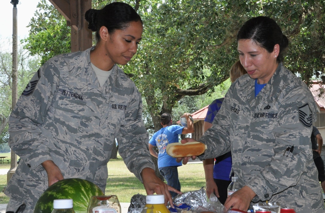 Master Sgt. Tainell Pettengill (L) and Master Sgt. Vianca Contreras sample goodies at the 340 Flying Training Group's picnic after the unit's spring MUTA held at Joint Base San Antonio, Texas, June 8-9.. (Photo by Janis El Shabazz, 340 FTG Public Affairs)