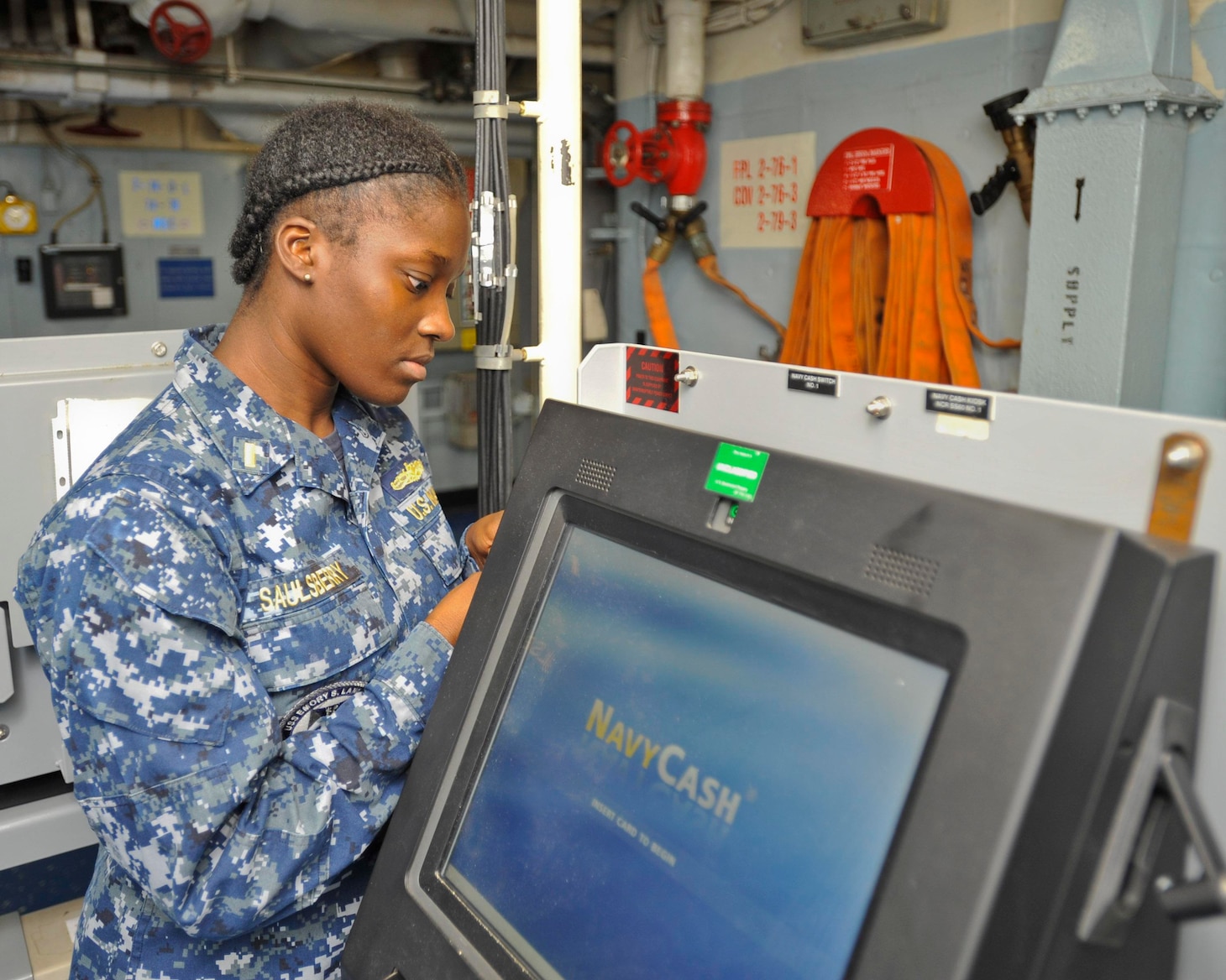 (POLARIS POINT, Guam) May 23, 2017 -- Ens. Brittany Saulsberry, disbursing officer aboard submarine tender USS Emory S. Land (AS 39), opens the front panel of one of the ship’s Navy Cash devices. Saulsberry was recently selected to serve as a supply officer aboard submarines as part of the Women in Submarine Service program. Land and sister ship USS Frank Cable (AS 40) provide maintenance, hotel services, and logistical support to submarines and surface ships in the U.S. 5th and 7th Fleet areas of operation. (U.S. Navy photo by Mass Communication Specialist 2nd Class Richard A. Miller/RELEASED)