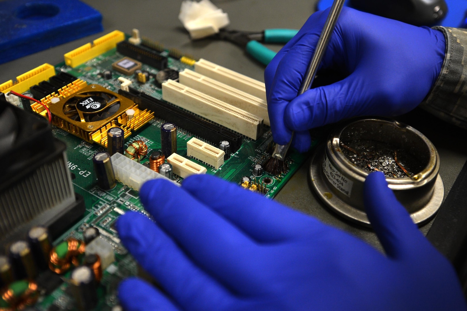 U.S. Air Force Staff Sgt. Alexander Creznic, 20th Maintenance Group Air Force Repair Enhancement Program (AFREP) technician, uses a wire brush to clean a capacitor removed from a computer’s motherboard at the AFREP work center at Shaw Air Force Base, S.C., June 12, 2017. The savings from this flight’s services have funded projects such as the 20th Component Maintenance Squadron paint booth and sun shades for Shaw’s 79 F-16CM Fighting Falcons.   (U.S. Air Force photo by Airman 1st Class Christopher Maldonado)
