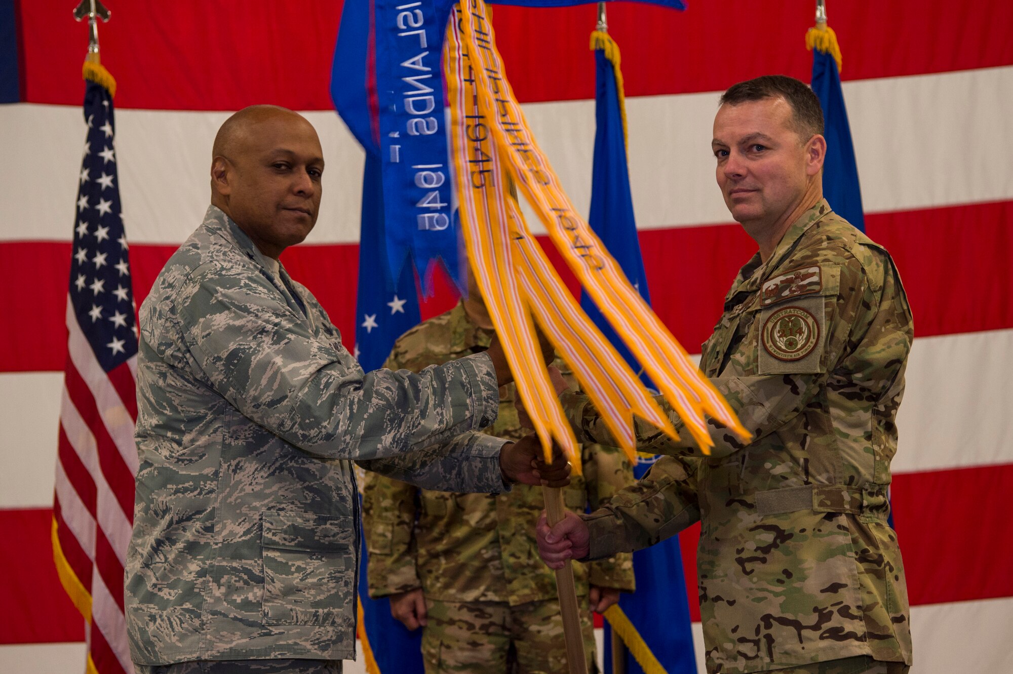 Maj. Gen. Anthony Cotton, 20th Air Force and Task Force 214 commander, passes the guidon to Col. Joshua Bowman, 582nd Helicopter Group commander, during the 582nd HG change-of-command ceremony at F.E. Warren Air Force Base, Wyo., June 13, 2017. The ceremony signified the transition of command from Col. David Smith. (U.S. Air Force photo by Staff Sgt. Christopher Ruano)
