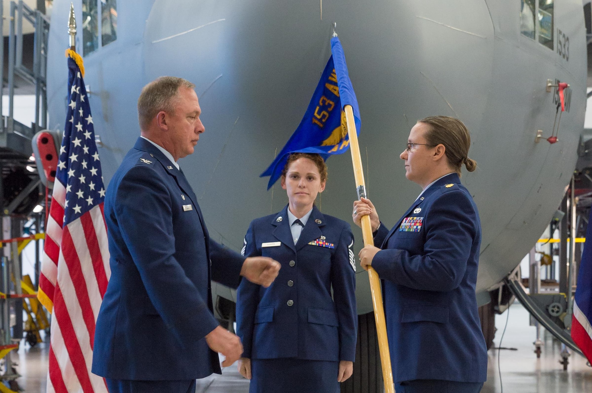 U.S. Air Force Col. Pete Linde, 153rd Maintenance Group commander, passes the 153rd Aircraft Maintenance Squadron guidon to Maj. Elizabeth Evans during an assumption of command ceremony June 10, 2017 in Cheyenne, Wyoming. Evans previously held the position of 153rd Maintenance Operations Flight commander.