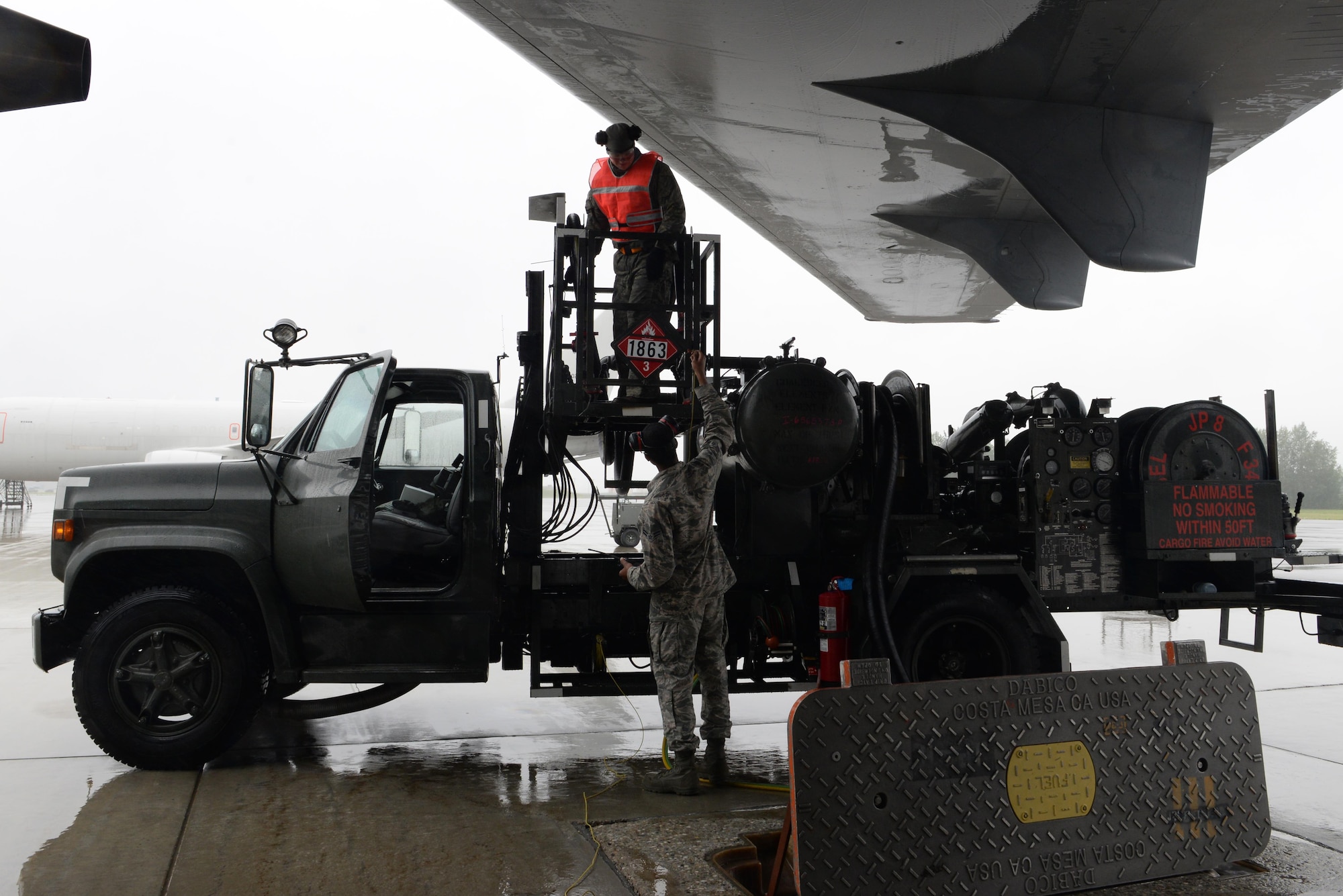U.S. Air Force Airman 1st Class Lorenzo Jackson, a 354th Logistics Readiness Squadron fuels distribution operator, passes a bonding wire up to a TDY Airman to refuel a KC-135 Stratotanker during RED FLAG-Alaska (RF-A) 17-2 June 12, 2017, at Eielson Air Force Base, Alaska. The fuels Airmen are busy day and night during RF-A exercises to fuel all participating aircraft. (U.S. Air Force photo by Airman 1st Class Cassandra Whitman)