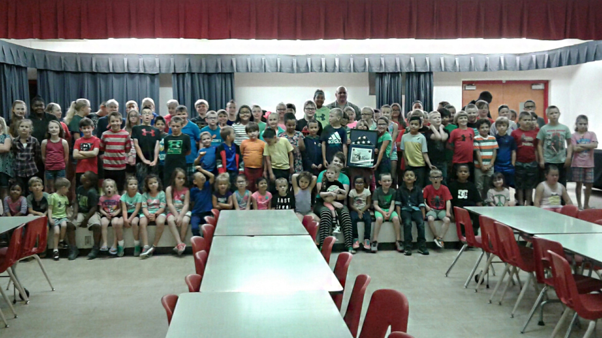 U.S. Air Force Master Sgt. Anthony Molina, 97th Maintenance Directorate inspection managements flight chief, and students from Duke Elementary School pose for a photo, May 17, 2017, at Duke Elementary School, Oklahoma. The students of Duke Elementary received a U.S. flag that had been flowing during combat operations overseas as thanks for writing deployed members during the holidays. (Courtesy Photo/Released).