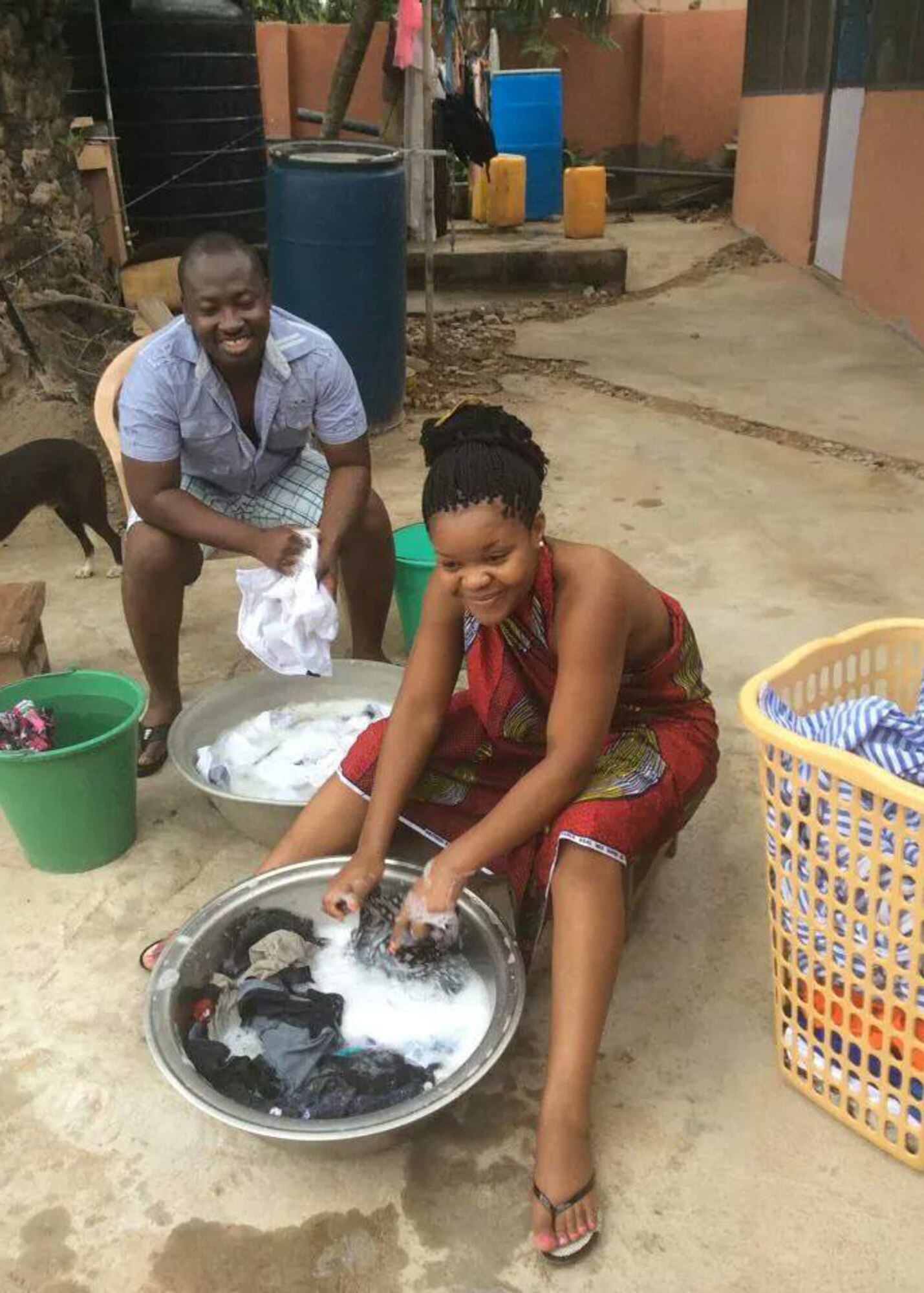 U.S. Air Force Staff Sgt. Francis Atchoe, a Detachment1, 3rd Air Support Operations Squadron personnel journeyman, and Airman 1st Class Brenda Atchoe, a 354th Force Support Squadron personnel journeyman, wash clothing while visiting Ghana, South Africa. Francis is originally from Ghana while Brenda is from Zimbabwe. (Courtesy Photo)