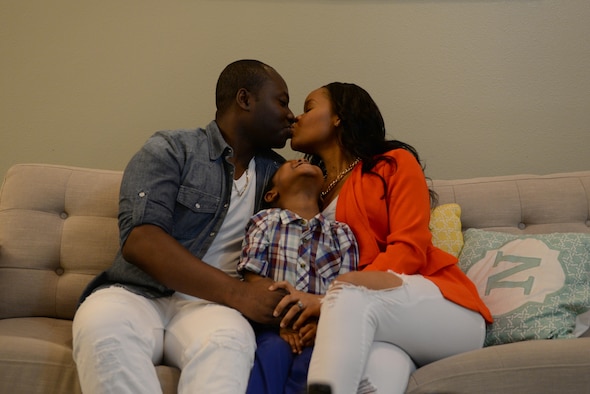 U.S. Air Force Staff Sgt. Francis Atchoe, a Detachment 1, 3rd Air Support Operations Squadron personnel journeyman, kisses his wife Airman 1st Class Brenda Atchoe, a 354th Force Support Squadron personnel journeyman, while their son Ethan laughs Feb. 15, 2017, at their home on Fort Wainwright, Alaska. The Atchoe’s met through a mutual friend while they were attending college at different universities and have since gained citizenship and hope to become officers in the Air Force. (U.S. Air Force photo by Airman 1st Class Cassandra Whitman)