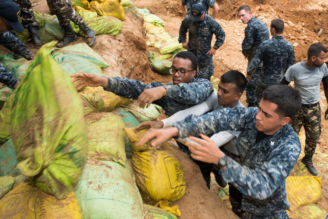 Sailors assigned to the USS Lake Erie work with Sri Lankan marines to repair levees in Matara, Sri Lanka, June 12, 2017, during humanitarian assistance operations following severe flooding and landslides in the country. Navy photo by Petty Officer 2nd Class Joshua Fulton