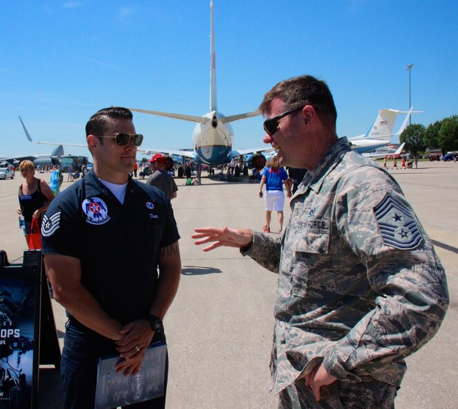 Technical Sgt. Joseph Olsen, an Air Transportation Specialist for the United States F-16 Thunderbirds team, talks with the top local reserve enlisted leader, 932nd Airlift Wing Command Chief Master Sgt. Chad Welch, about the Illinois unit's C-40C aircraft (seen in background).  Various wing members told their particular stories regarding their unique jobs to the general public at the Scott Air Show June 10, 2017, at Scott Air Force Base, Illinois.  (U.S. Air Force photo by Lt. Col. Stan Paregien)