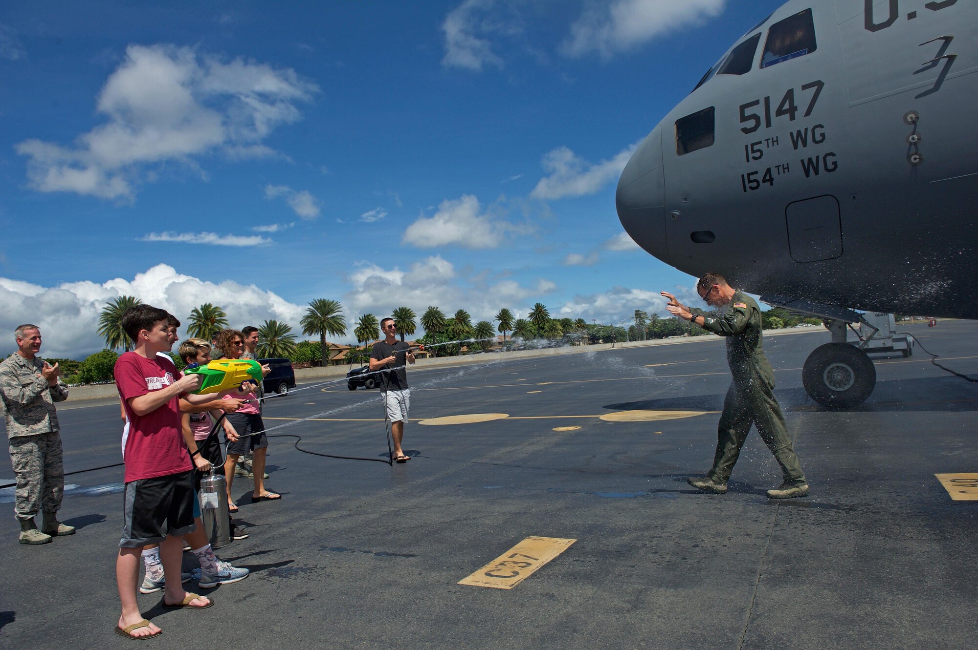 U.S. Air Force Maj. Gen. Mark Dillon, Pacific Air Forces vice commander, is greeted by family and friends and soaked in water and champagne moments after his C-17 fini-flight at Joint Base Pearl Harbor-Hickam, Hawaii, June 12, 2017. With Dillon's retirement approaching, the fini-flight is the capstone event of his flying career. (U.S. Air Force photo/Tech. Sgt. Kamaile Chan)