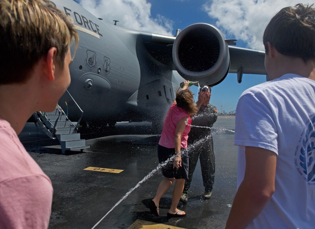U.S. Air Force Maj. Gen. Mark Dillon, Pacific Air Forces vice commander, is greeted by family and friends and soaked in water and champagne moments after his C-17 fini-flight at Joint Base Pearl Harbor-Hickam, Hawaii, June 12, 2017. With Dillon's retirement approaching, the fini-flight is the capstone event of his flying career. (U.S. Air Force photo/Tech. Sgt. Kamaile Chan)