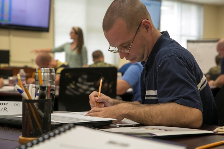 CAMP FOSTER, OKINAWA, Japan – Petty Officer 1st Class Arthur Leuschen fills out the example worksheet during the Command Financial Specialist Training June 5 aboard Camp Foster, Okinawa, Japan. The Personal Financial Management Specialists had the Marines and Sailors fill out these spreadsheets in order to properly understand what their Marines will be going through. A CFS acts as the liaison between Marines and PFM, and are equipped to answer basic financial questions.  (U.S Marine photo by Lance Corporal Tayler P. Schwamb)