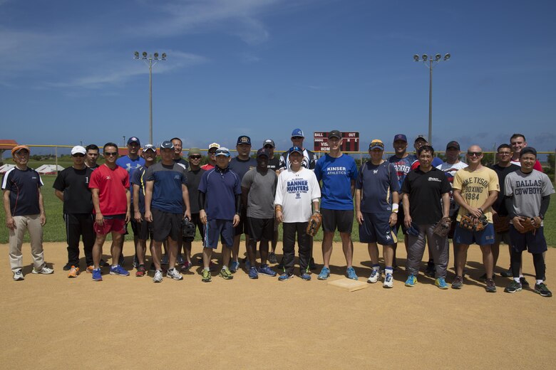 Players pose for a group photo before a friendship softball game and barbecue June 11 aboard Camp Kinser, Okinawa, Japan. Leaders of the military and local community participated in this event: the mayor of Urasoe City, members of the Japan Ground Self-Defense Force, members of city hall, members of the Urasoe City Police Department, the U.S. consul, the sergeant major of Camp Kinser, Col. Christopher Feyedelem, the Camp Kinser camp commander and Marines from Camp Kinser. The large group integrated making two teams and played a friendly game of softball with an all-American barbecue for lunch.