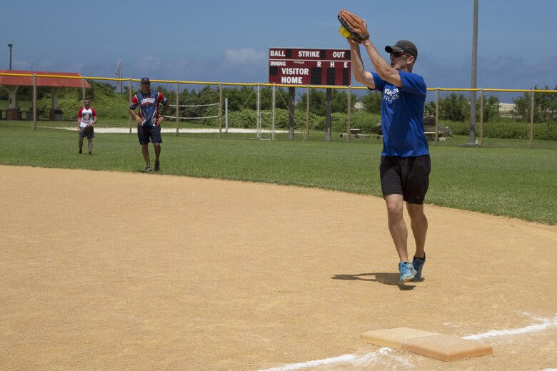 Col. Christopher Feyedelem catches a ball at first base during a friendship softball game June 11 aboard Camp Kinser, Okinawa, Japan. Members of the Japan Ground Self-Defense Force, Urasoe Police Department, City Hall, the mayor of Urasoe, the U.S. consul and Marines came together for a friendly game of softball followed by an all-American lunch of hotdogs and hamburgers. Feyedelem is the Camp Kinser camp commander and commanding officer of 3rd Marine Logistics Group, Headquarters Regiment.