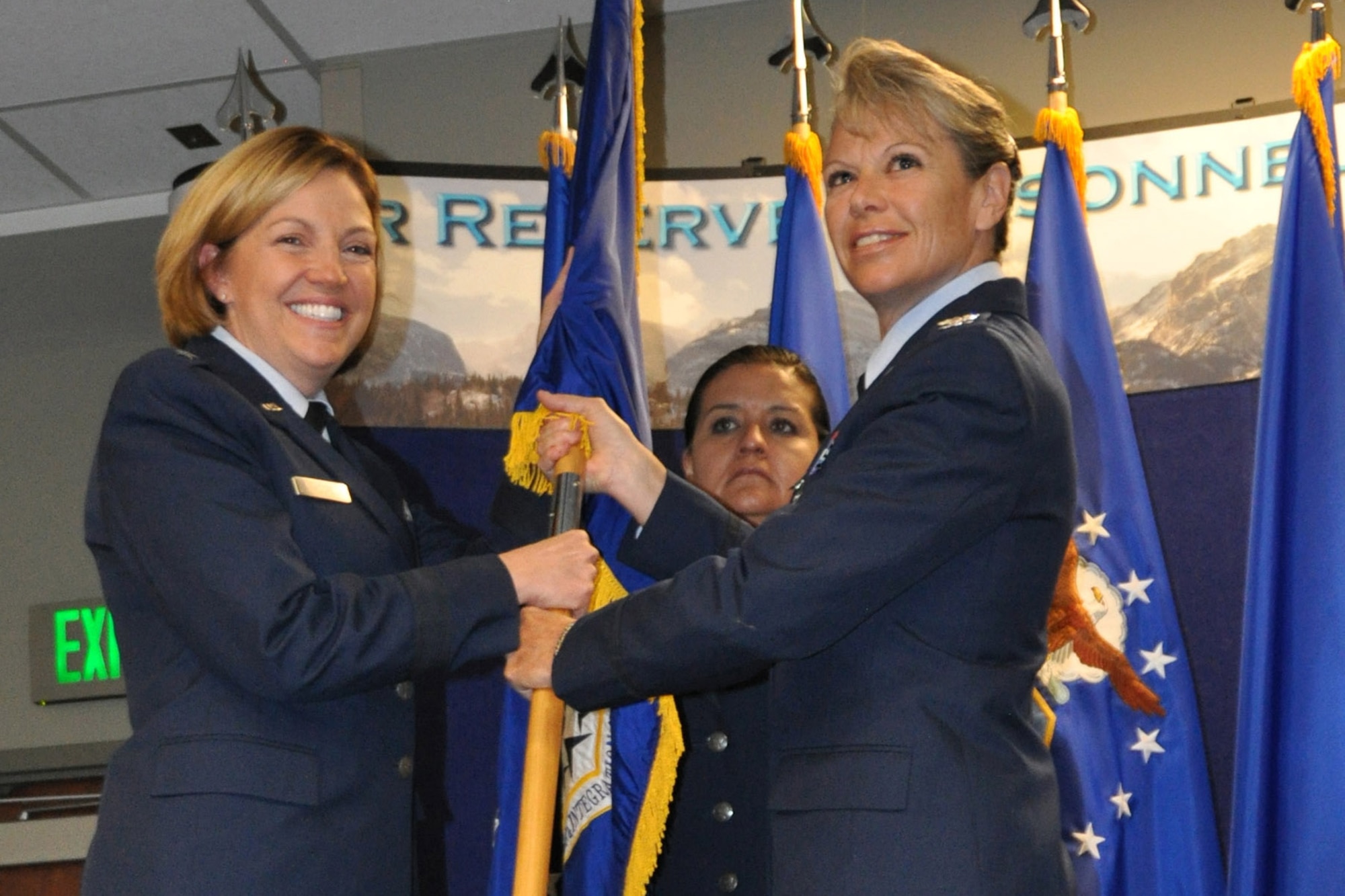 Col. Carolyn Stickell (right) relinquishes her command of the Headquarters Individual Reservist Readiness and Integration Organization, June 12. Stickell passed the HQ RIO guidon to Brig. Gen. Ellen Moore, the Headquarters Air Reserve Personnel Center Commander, who presided over the ceremony and later presented the guidon to the new HQ RIO commander, Col. Kelli B. Smiley.