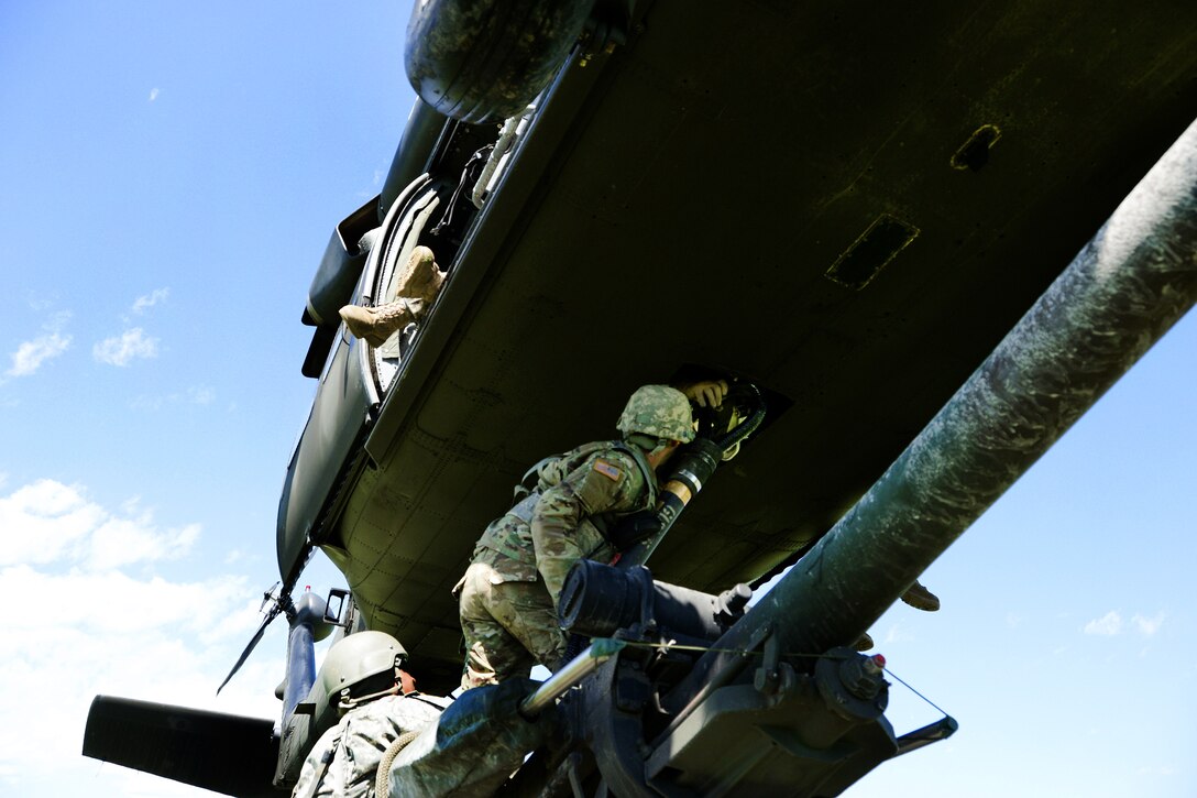 New York Army National Guardsmen hook up an M119A2 howitzer to a UH-60 Black Hawk helicopter during slingload training at Fort Drum, N.Y., June 8, 2017. Army National Guard photo by Pfc. Andrew Valenza