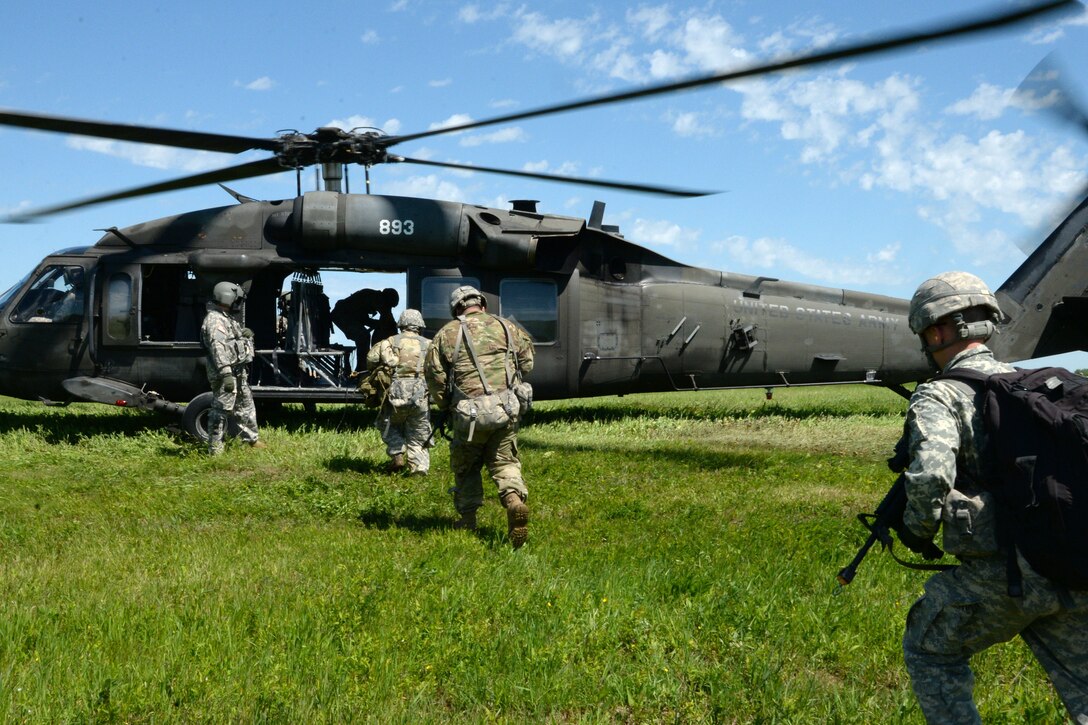 New York Army National Guardsmen rush to board a UH-60 Black Hawk helicopter during slingload training at Fort Drum, N.Y., June 8, 2017. Army National Guard photo by Pfc. Andrew Valenza