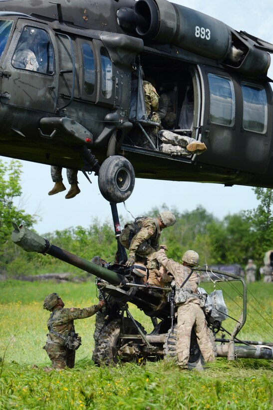 New York Army National Guardsmen hook up an M119A2 howitzer to a UH-60 Black Hawk helicopter during slingload training at Fort Drum, N.Y., June 9, 2017. Army National Guard photo by Pfc. Andrew Valenza