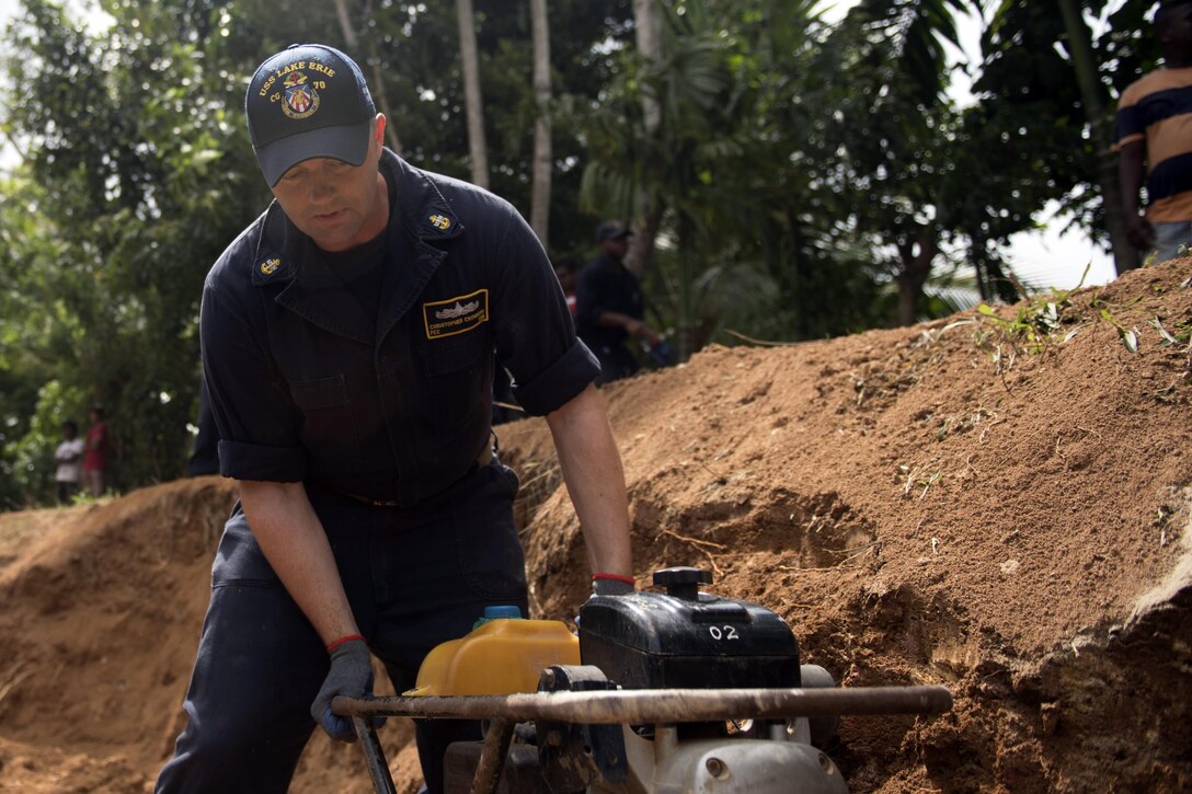 Navy Chief Petty Officer Christopher Kronberg assigned to the Ticonderoga-class guided missile cruiser USS Lake Erie compacts dirt to rebuild a road to support humanitarian assistance operations in the wake of severe flooding and landslides that devastated many regions of the country in Matara, Sri Lanka, June 13, 2107. Recent heavy rainfall brought by a southwest monsoon triggered flooding and landslides throughout the country, displacing thousands of people and causing significant damage to homes and buildings. Navy photo by Petty Officer 3rd Class Lucas T. Hans