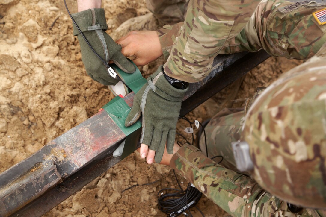 Soldiers attach C-4 explosives to a beam during demolition training at the Bemowo Piskie training area in Poland, June 7, 2017. Army photo by Spc. Samuel Brooks