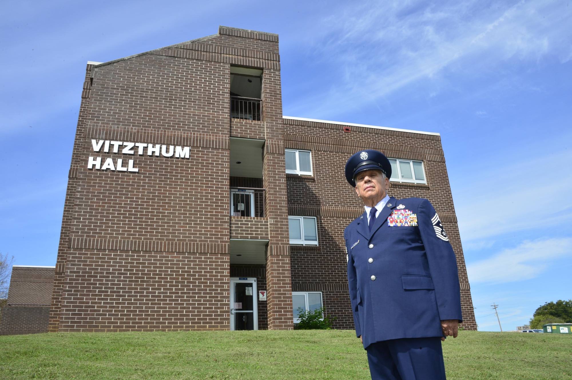 Retired Chief Master Sgt. George Vitzthum stands with the building in his name at the time of its 2015 dedication. The dormitory first opened in 1993 and began major renovations in 2016. Chief Vitzthum was part of the first leadership school and officer preparatory academy staff who then served as the second Commandant. He also instructed NCO academy. Chief Vitzthum helped develop much of the primary curriculum and contributed to the first college credits being awarded for EPME in the Air Force, among other accomplishments.