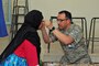 Senior Airmen Victor Garcia, an aerospace medical technician with the 151st Medical Group, adjusts a new pair of glasses for a patient in the optometry clinic in Akka Ighane, Morocco on April 21, 2017. (U.S. Air National Guard photo by Tech. Sgt. Annie Edwards)